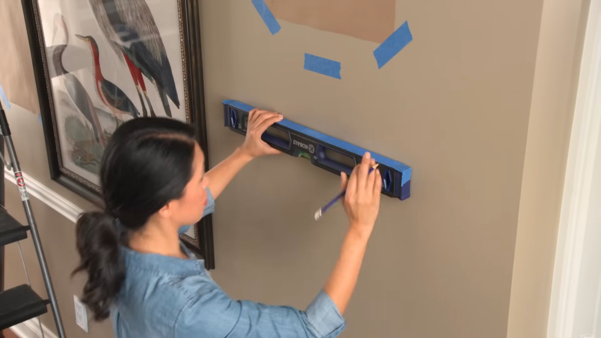 Using a level tool to ensure straight and correct picture placement on a wall