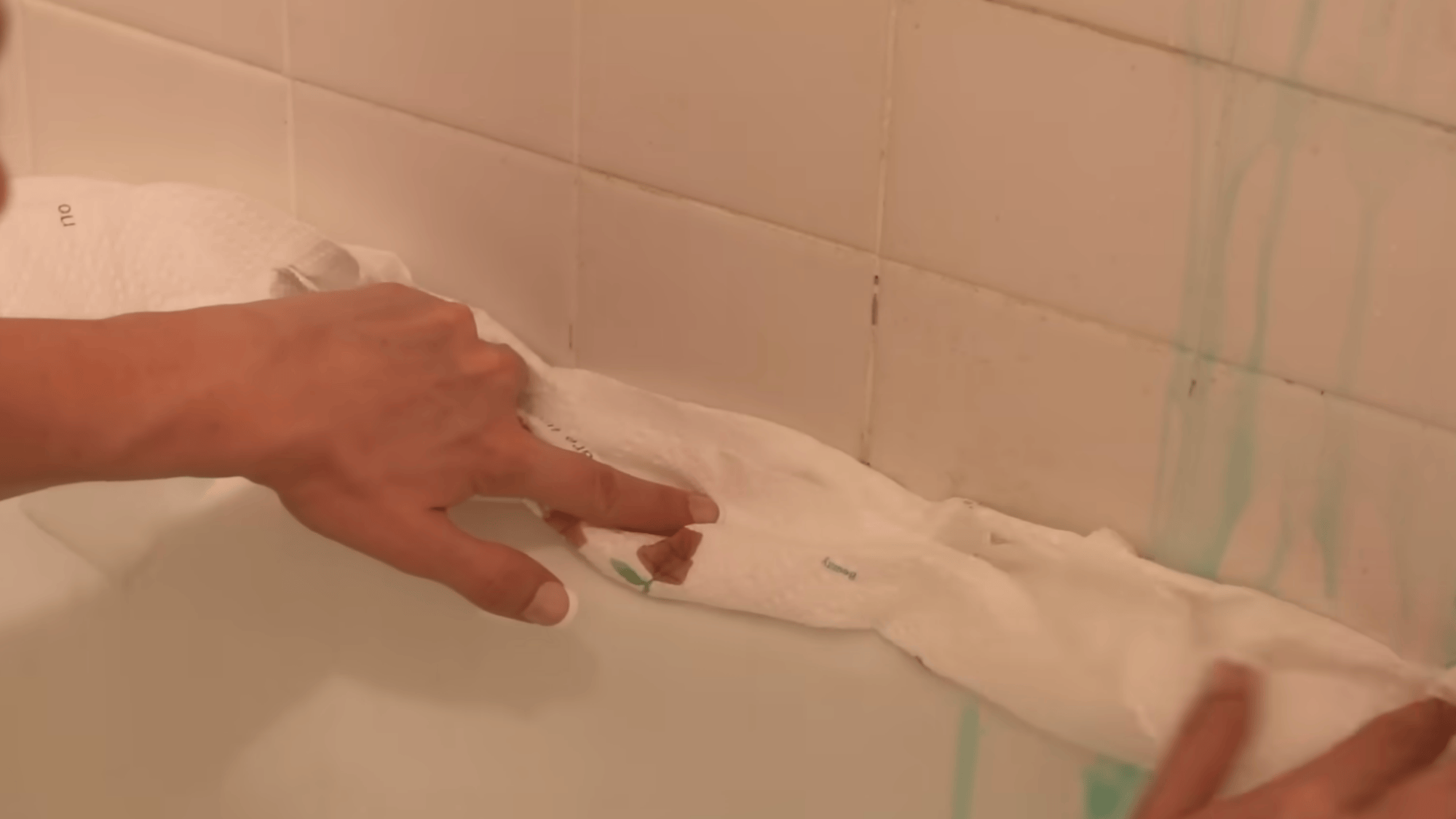 using paper towels to hold cleaner on shower mold area