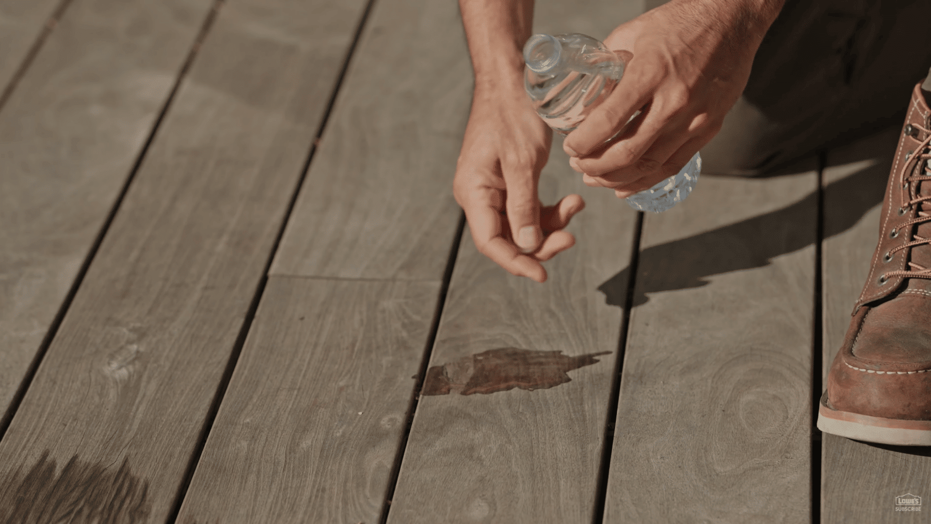 water soaking into weathered deck boards during stain protection test before refinishing wooden deck