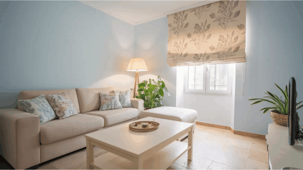 what is a roman shade floral roman shade partly lowered over small window beside sofa lamp and indoor plant