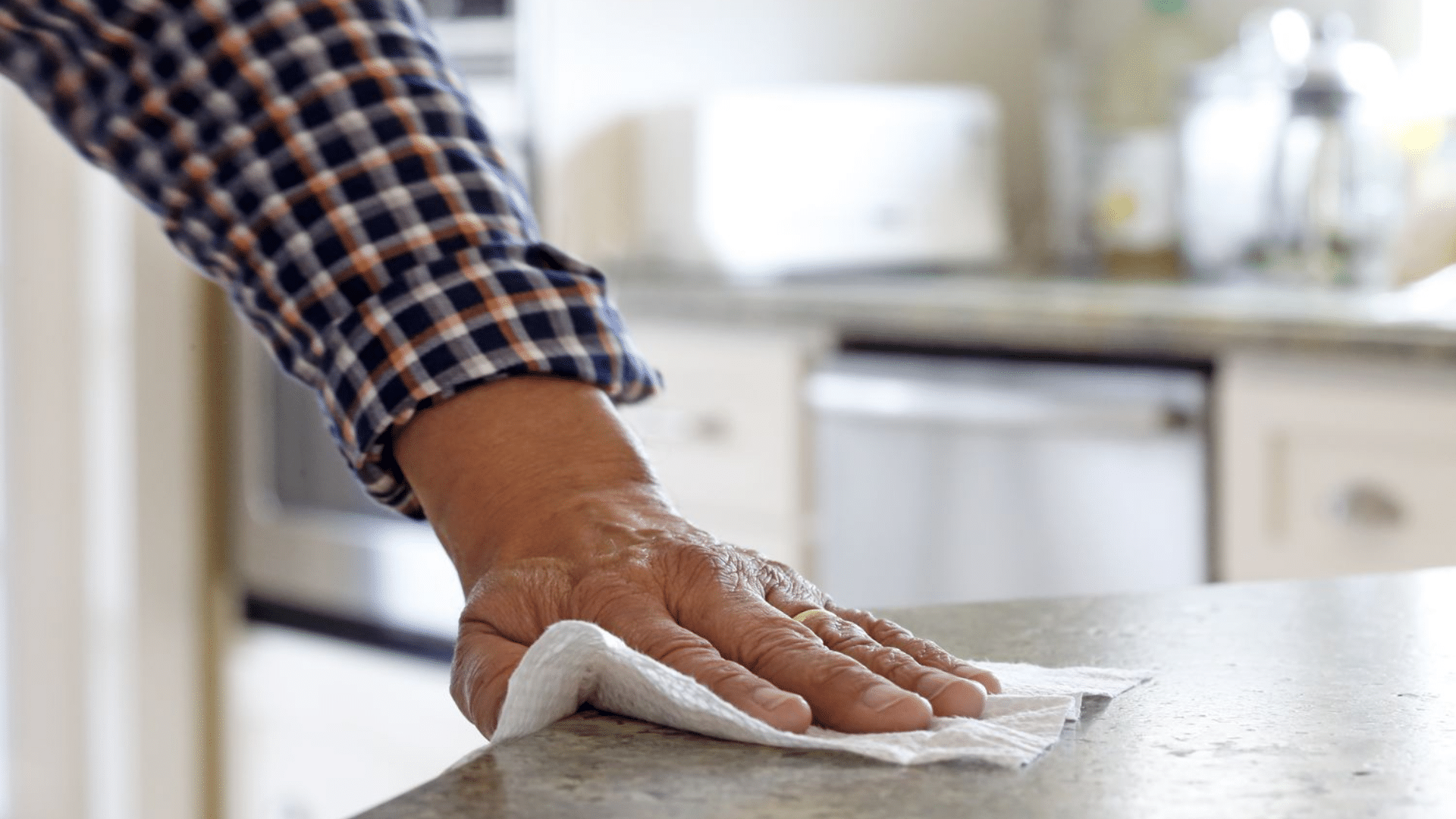 wiping kitchen counter surface part of daily house cleaning