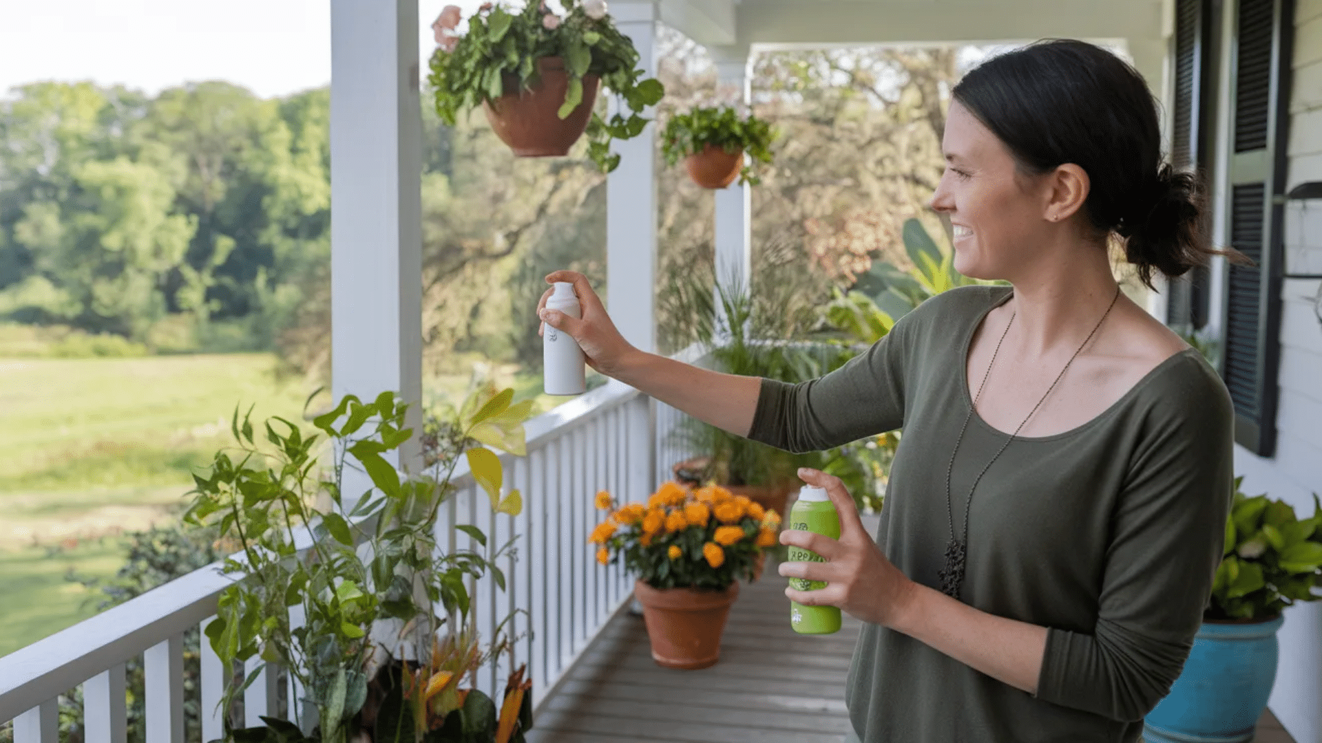 woman spraying natural citrus scent solution on porch plants to repel birds