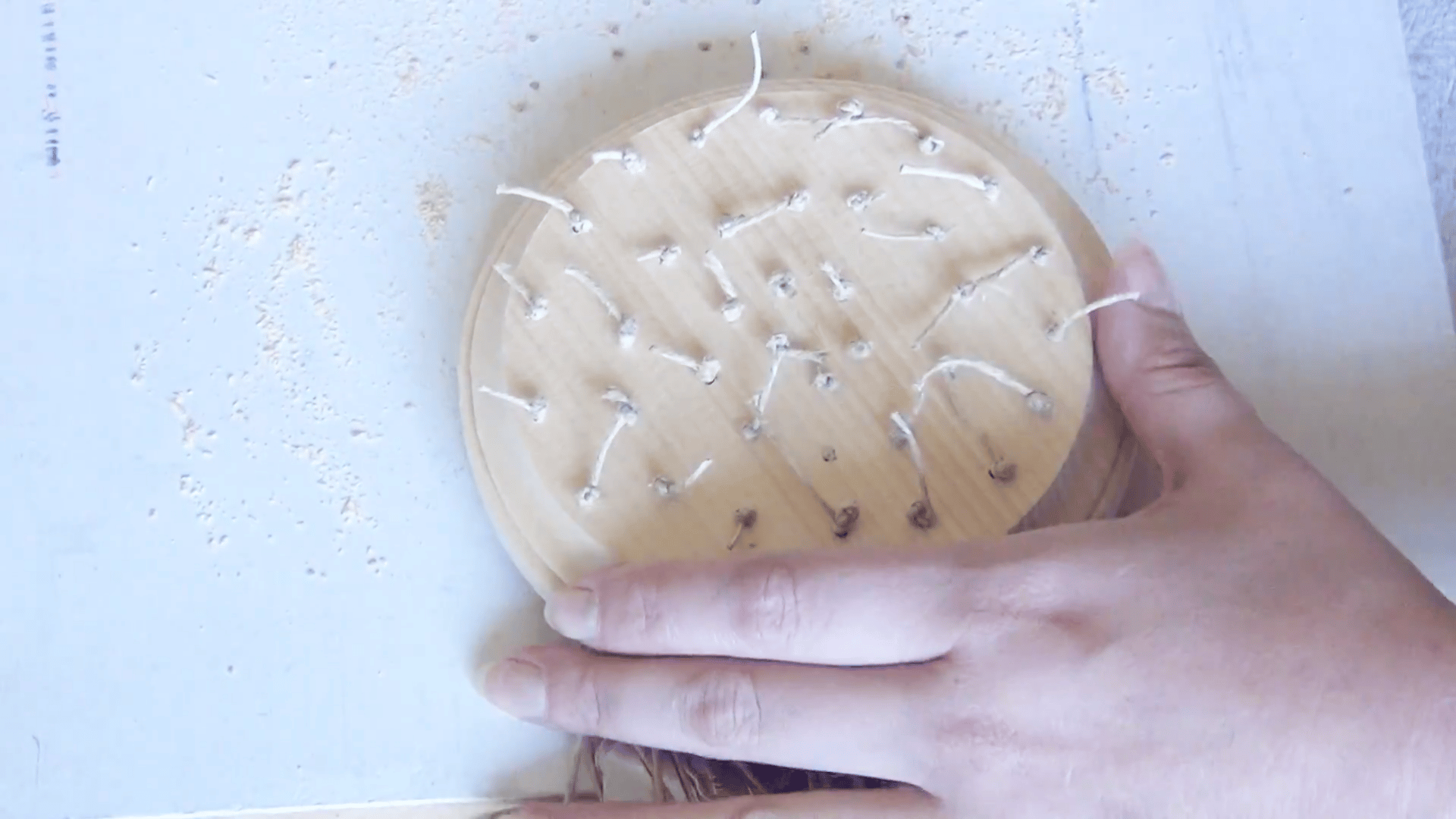 wooden round with tied hemp strings prepared for hanging keys in a diy wind chime craft project