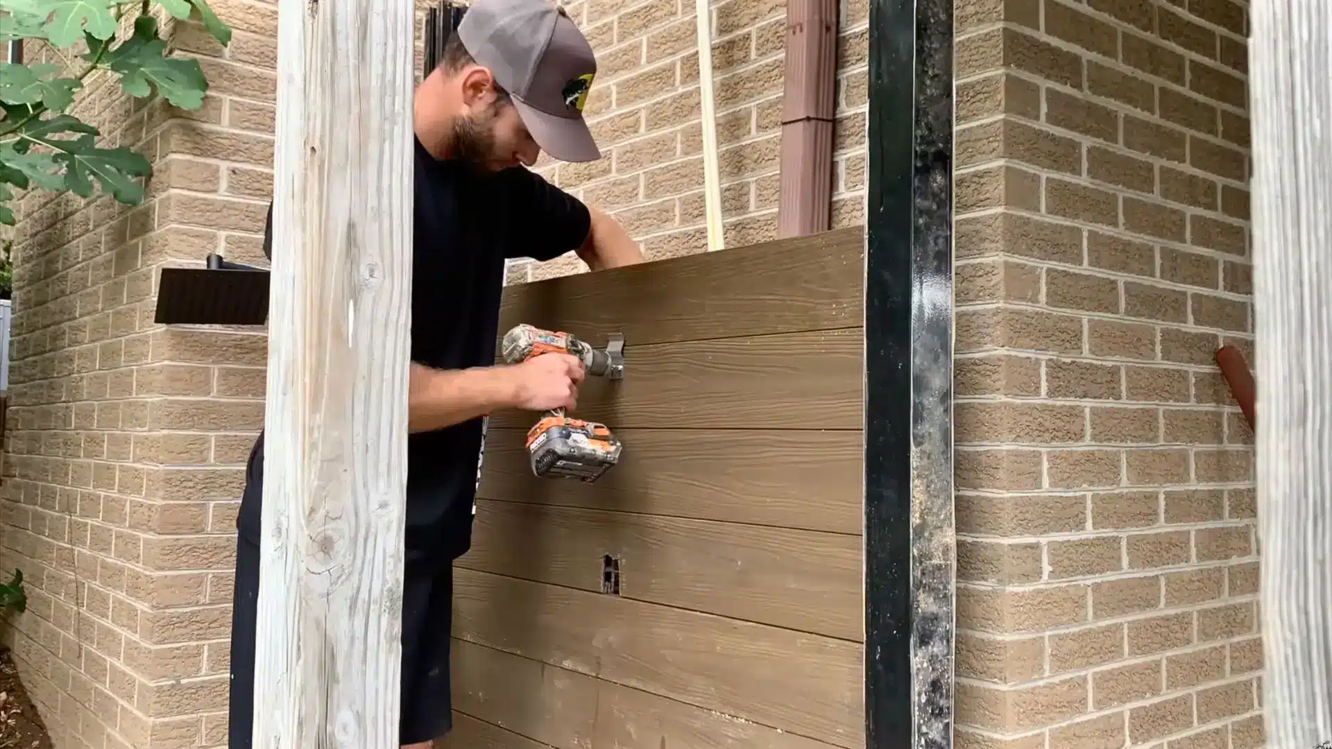 Completed wooden wall frame with 2x4 structure and cedar panels, showing sealed outdoor shower enclosure.