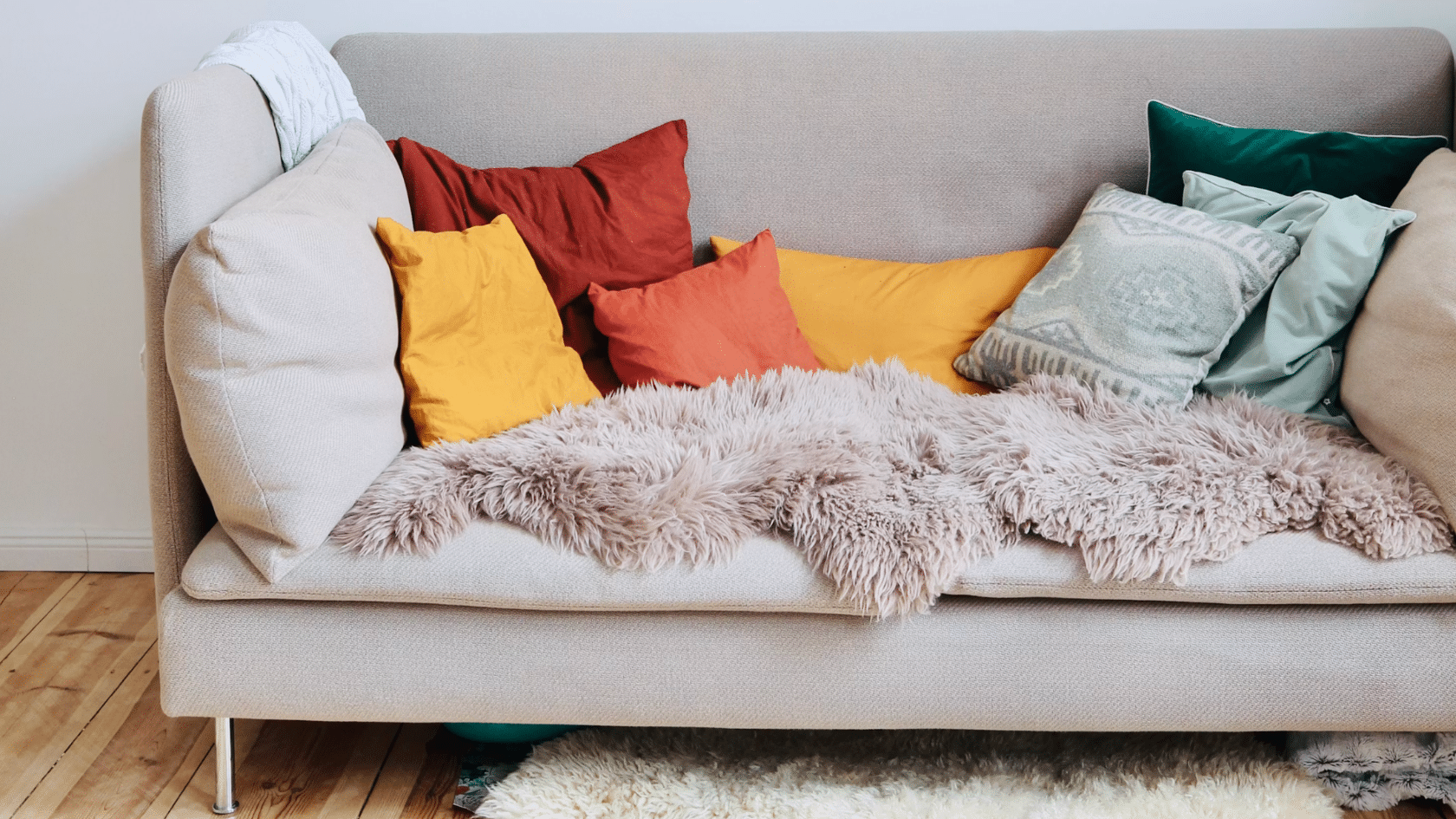 beige sofa with colorful accent cushions and a soft faux fur throw creating a cozy inviting seating area