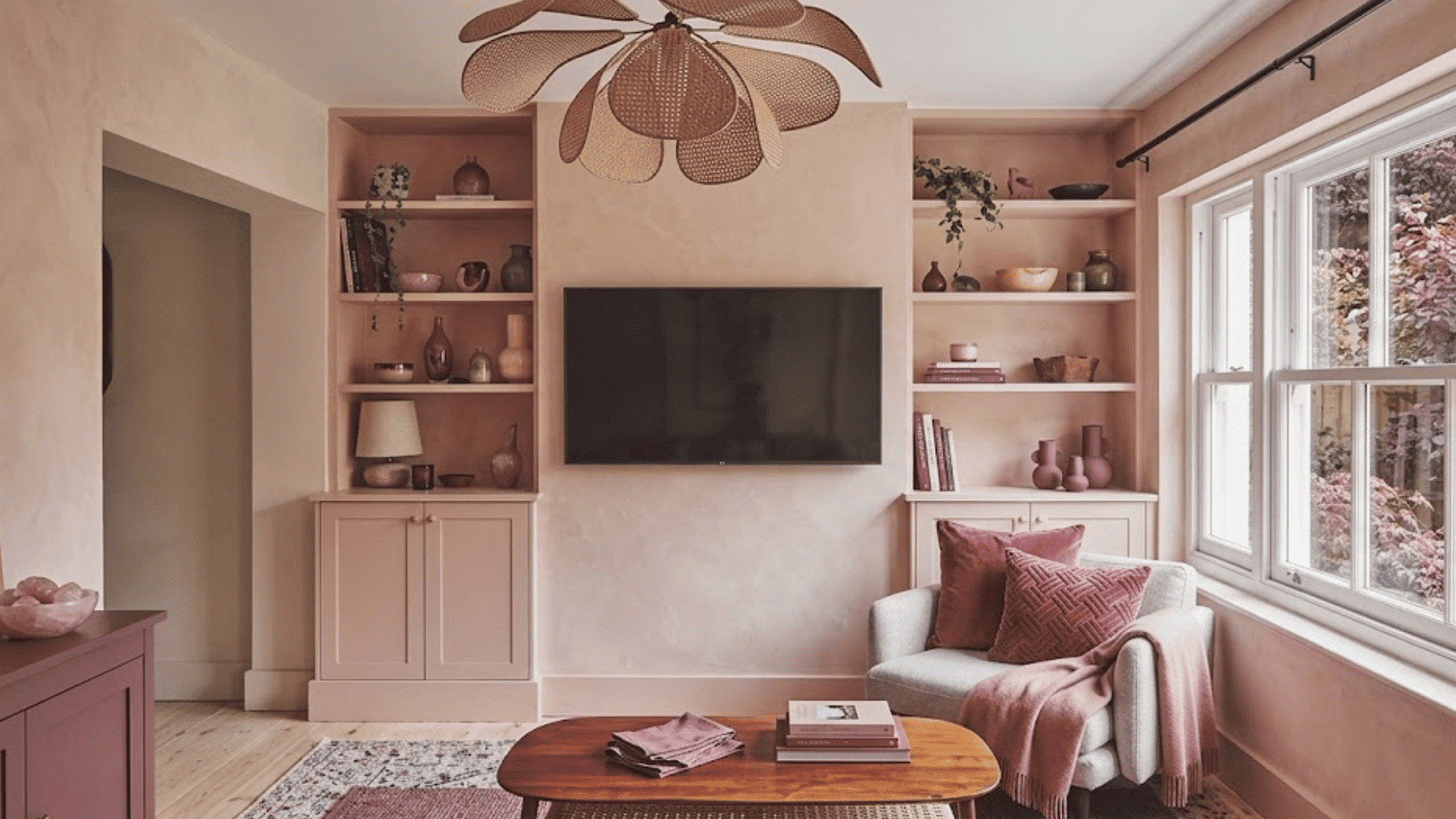 blush pink monochromatic living room with layered pink accents built in shelving and soft textured furnishings
