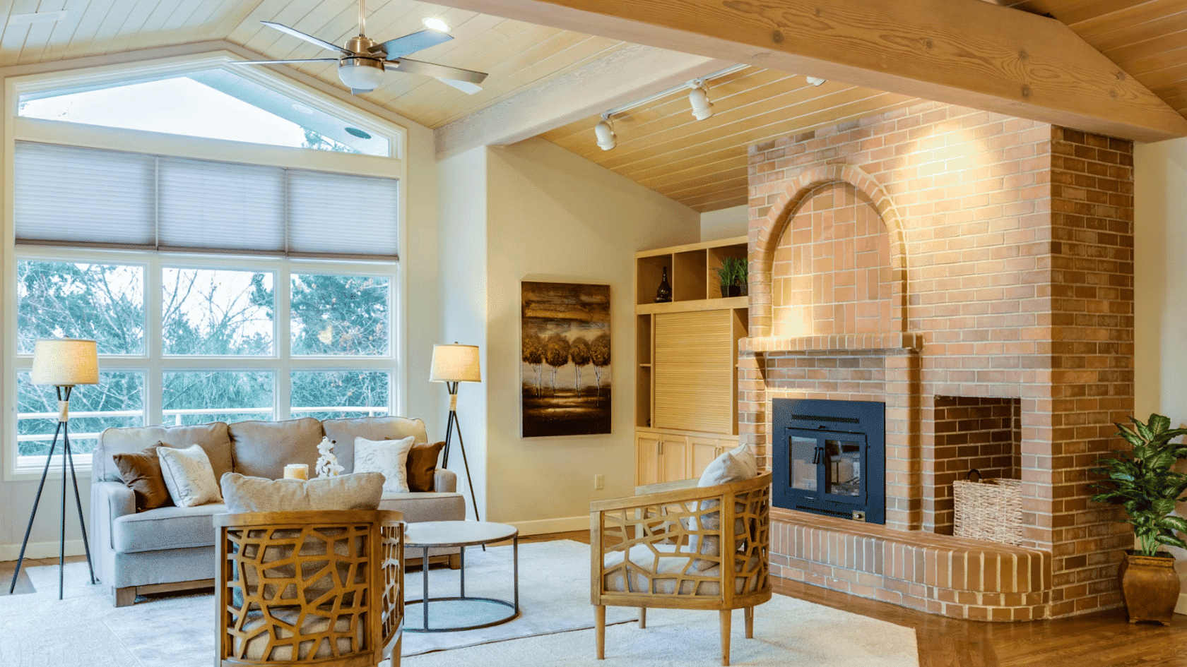Bright living room with brick fireplace vaulted wood ceiling large windows and comfortable seating area