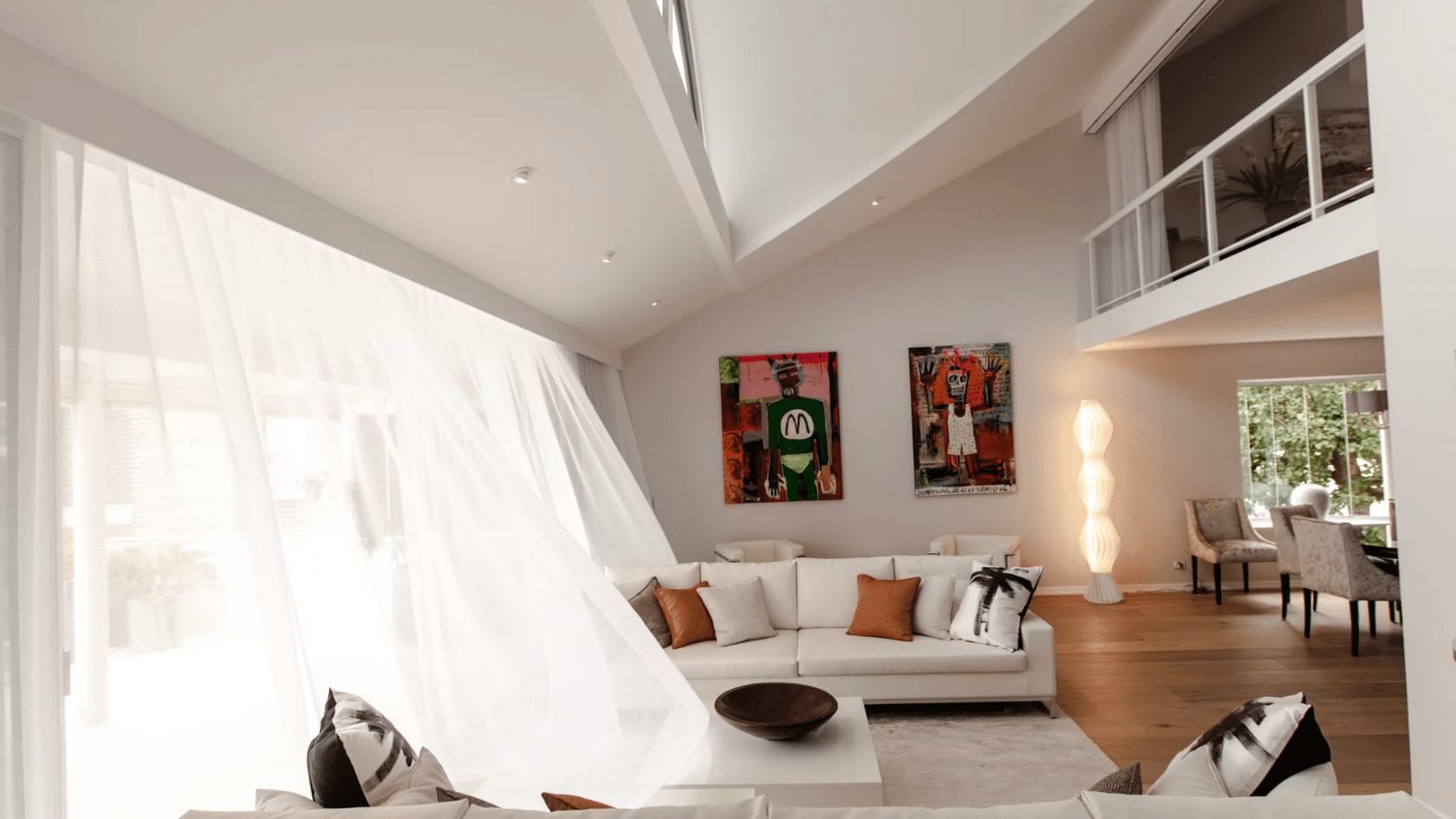 Contemporary living room with vaulted ceiling skylight white sofas and mezzanine overlooking open space