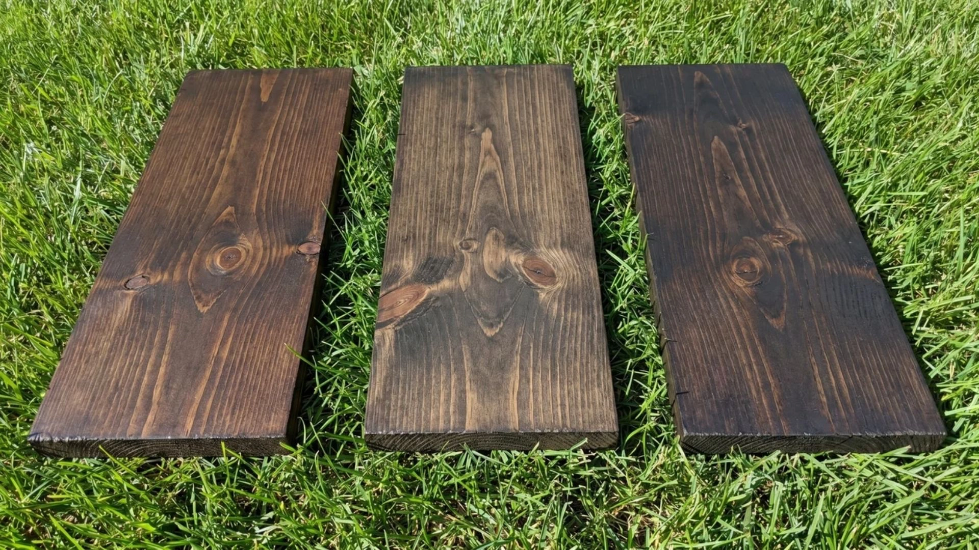 dark stained pine boards including walnut and espresso placed on grass showing deep grain contrast