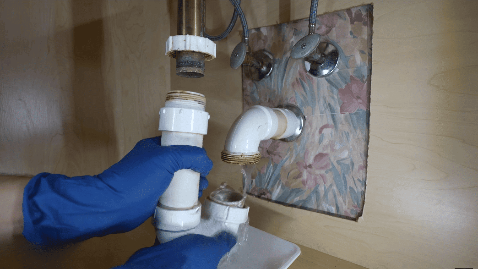 disconnecting sink drain pipe beneath vanity to create workspace for faucet replacement