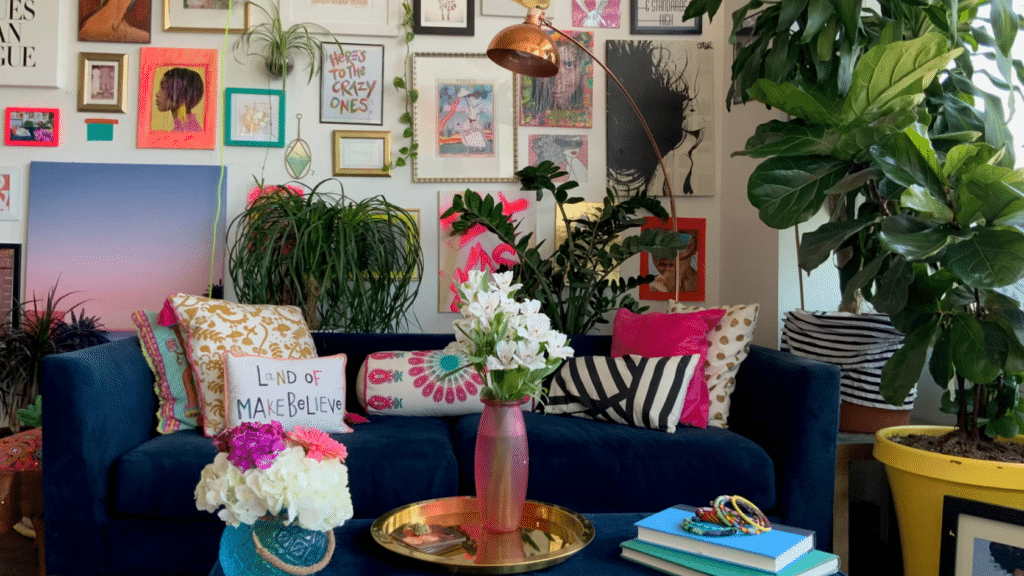 21 Maximalist Interior Design Ideas for Your Home eclectic living room with blue sofa colorful cushions indoor plants and a gallery wall of framed artwork and prints
