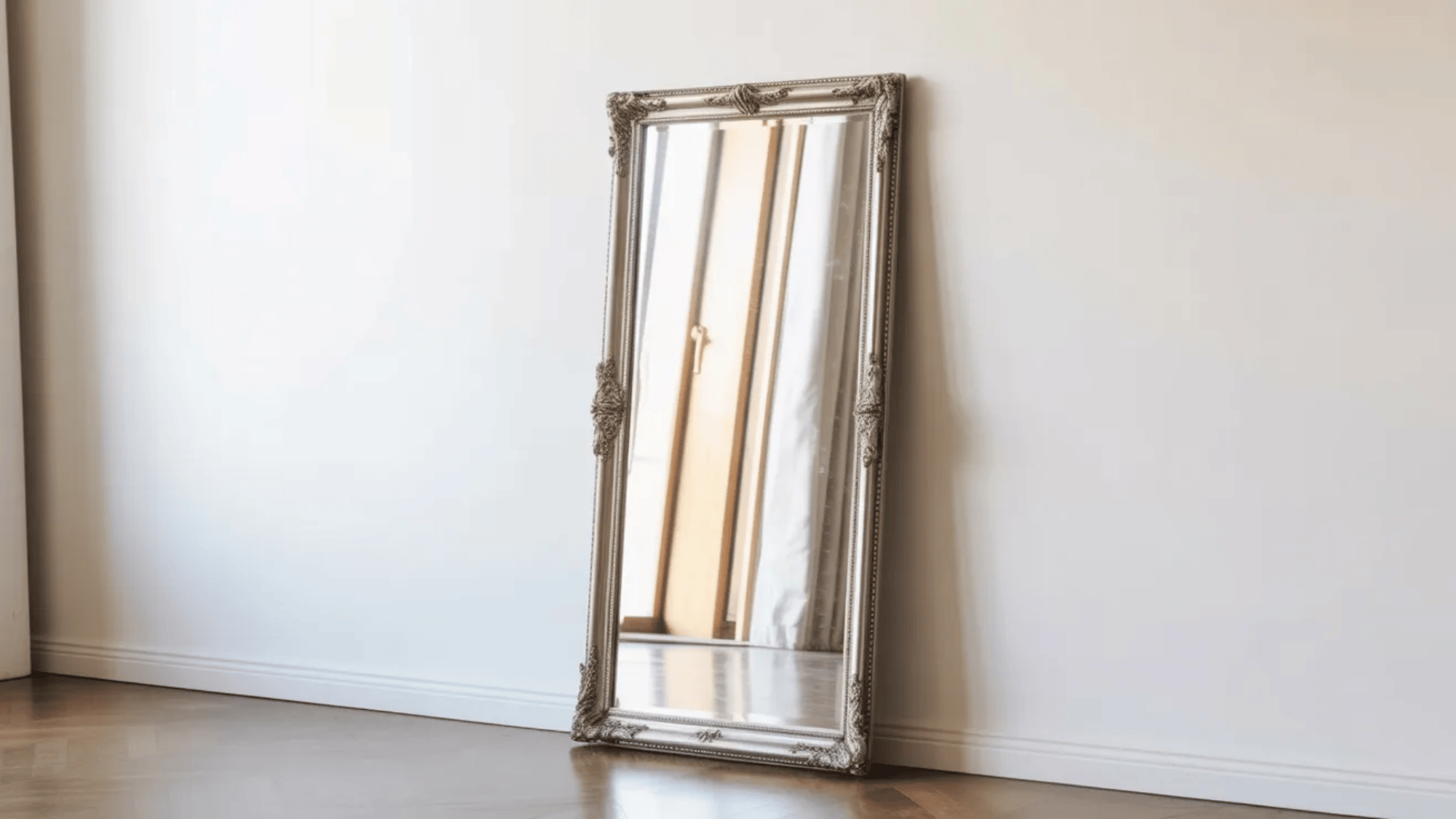 guest room ideas tall decorative floor mirror leaning against wall reflecting window light in bright minimal guest bedroom