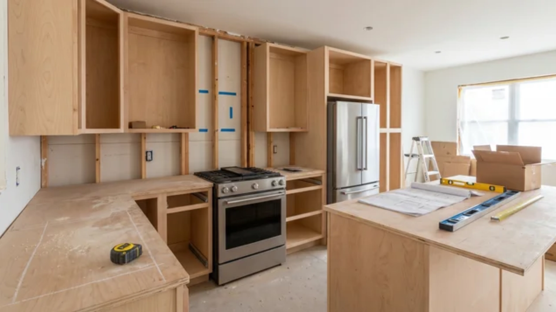 Kitchen interior with cabinets, appliances, and measuring tools used for layout planning