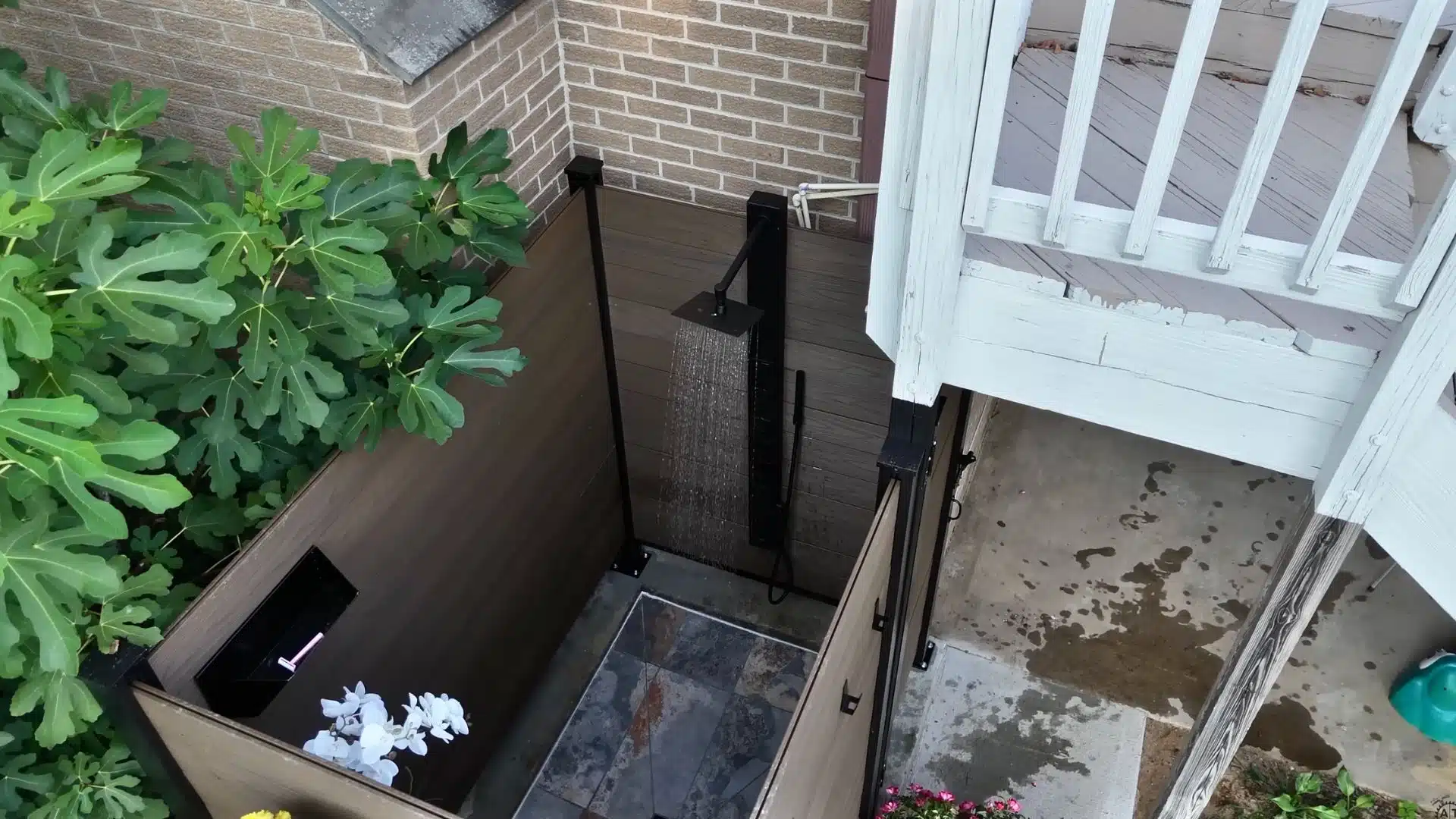 Outdoor shower plumbing connected with pipes, valve, and shower head installed and water tested for leaks.