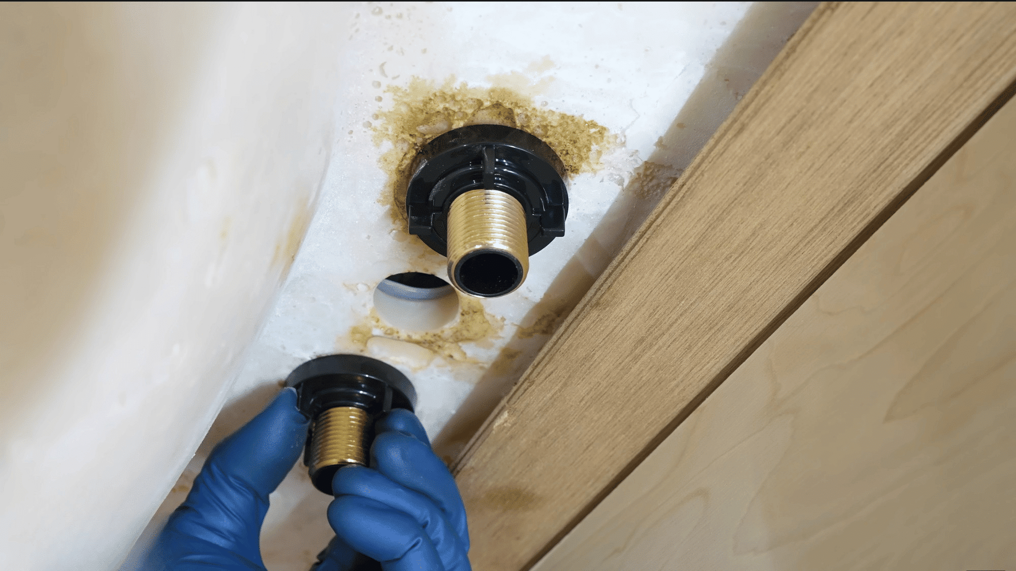 installing mounting hardware beneath sink to secure new bathroom faucet in place