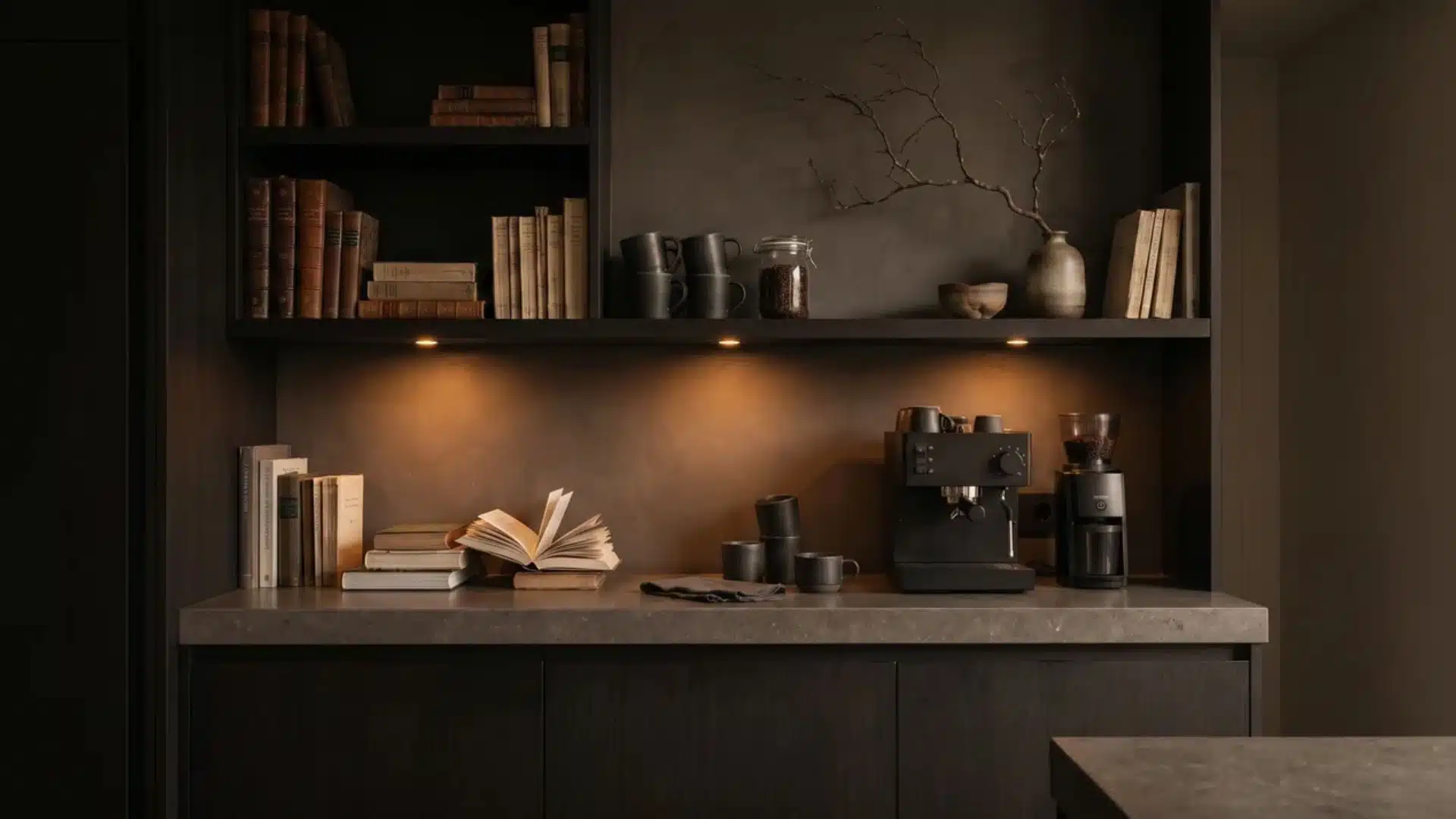 Dark Japandi coffee bar with blackened oak cabinets, stone counter, puck lighting, espresso machine, mugs, and minimal styling.