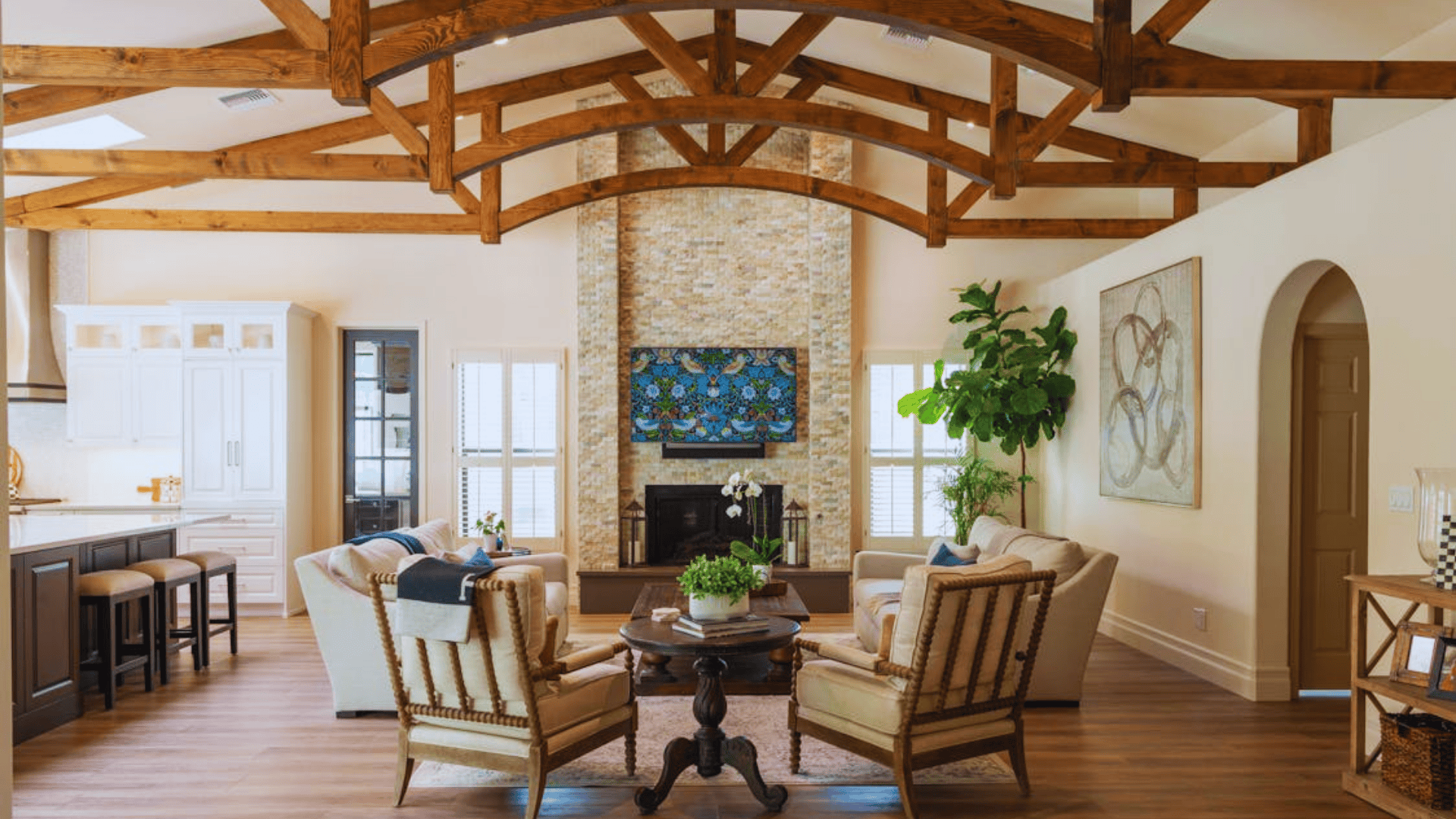 living room with wooden beams fireplace armchairs and open kitchen space