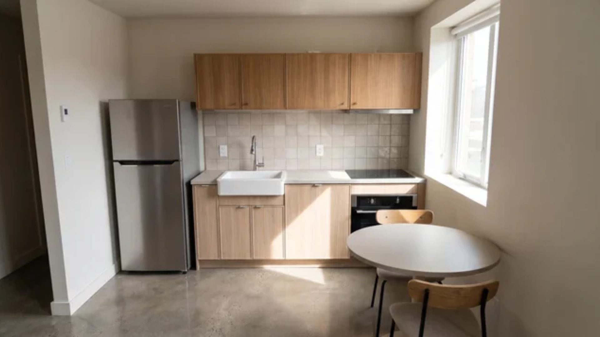 Compact kitchen with refrigerator, sink, and cooktop arranged along a single wall