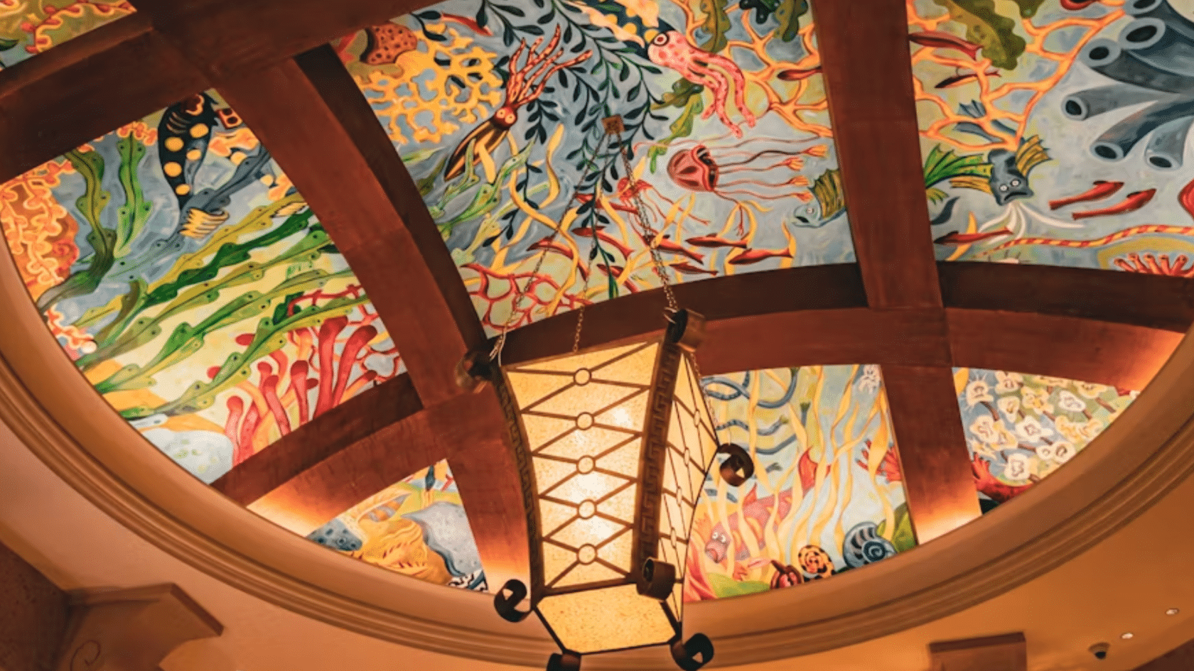 ornate domed ceiling mural with colorful underwater sea life artwork wooden beams and a hanging lantern light fixture