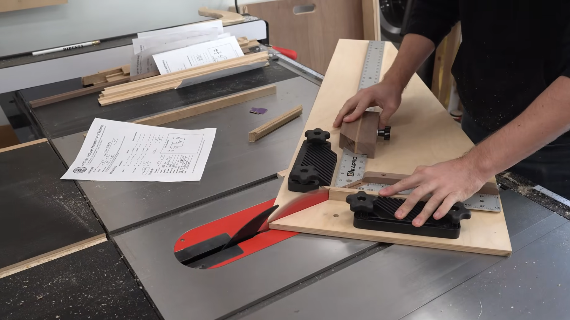 person using a crosscut sled and stop block on a table saw to make precise angled cuts on narrow wooden frame pieces