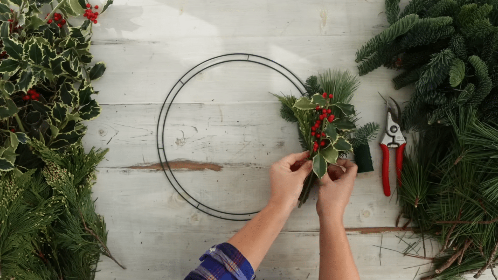 placing the first greenery bundle on the frame and wrapping it firmly with paddle wire