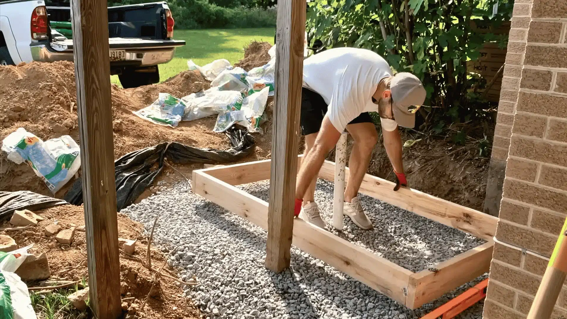 Ground cleared and leveled with slope, weed barrier and sand base prepared for outdoor shower floor drainage.