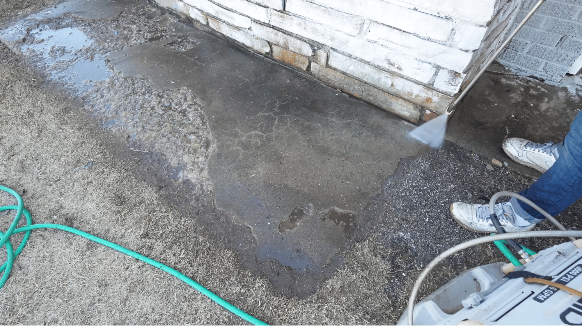 pressure washing damaged concrete walkway to remove dirt debris and loose material before repair work begins