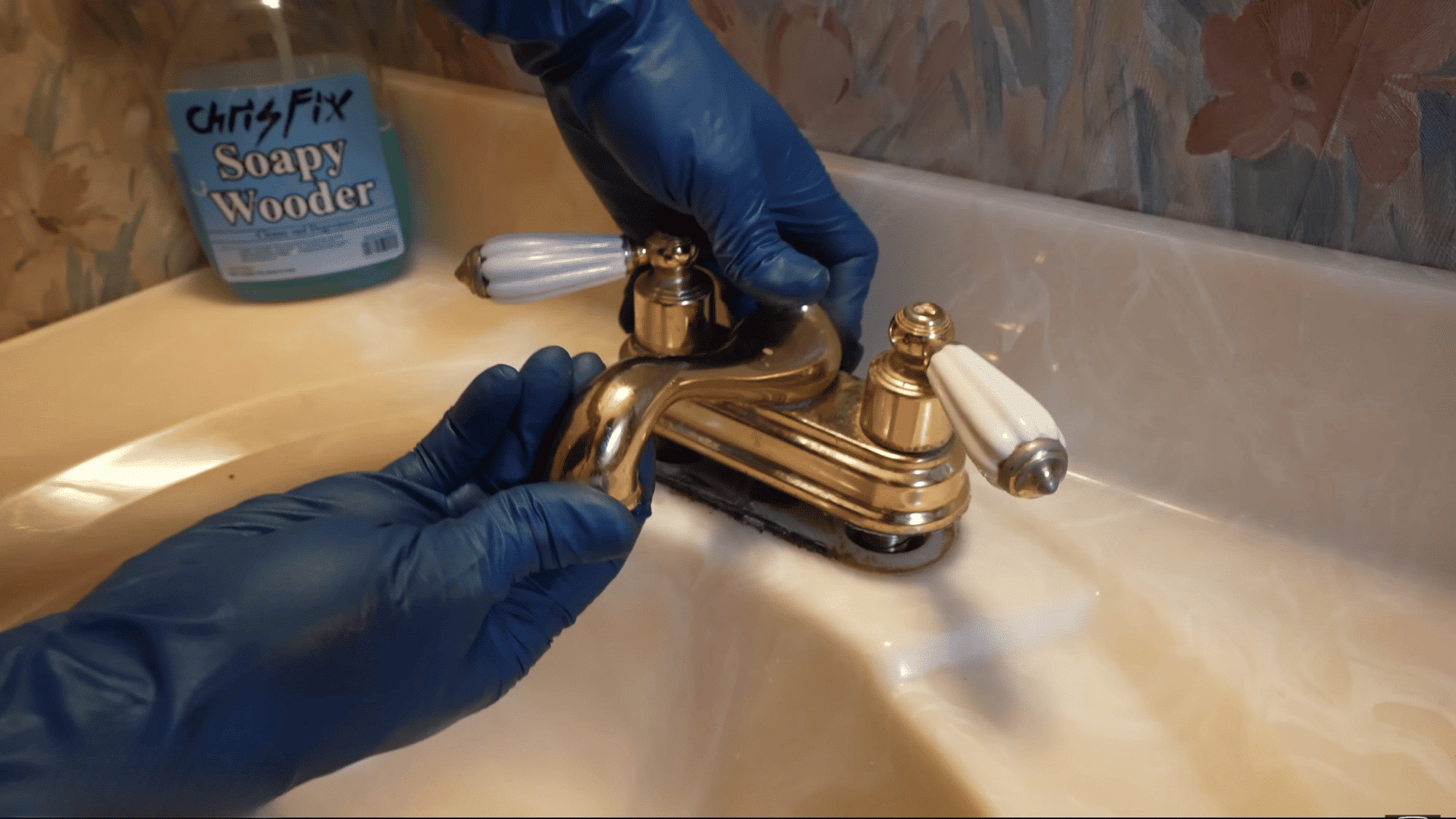 removing old bathroom faucet from sink countertop during a bathroom faucet replacement project