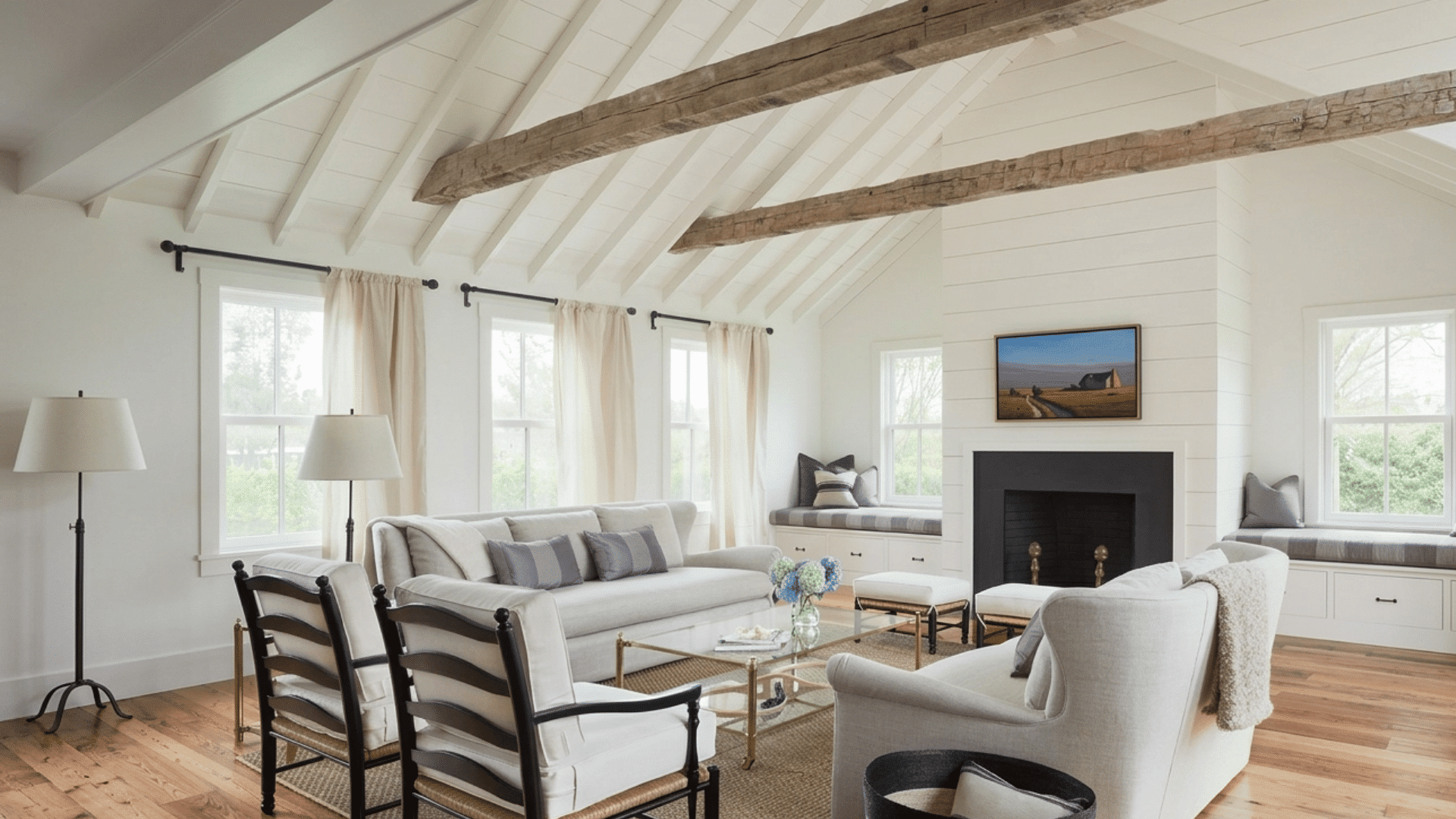 rustic living room with vaulted white ceiling exposed wood beams fireplace and light neutral furniture seating area