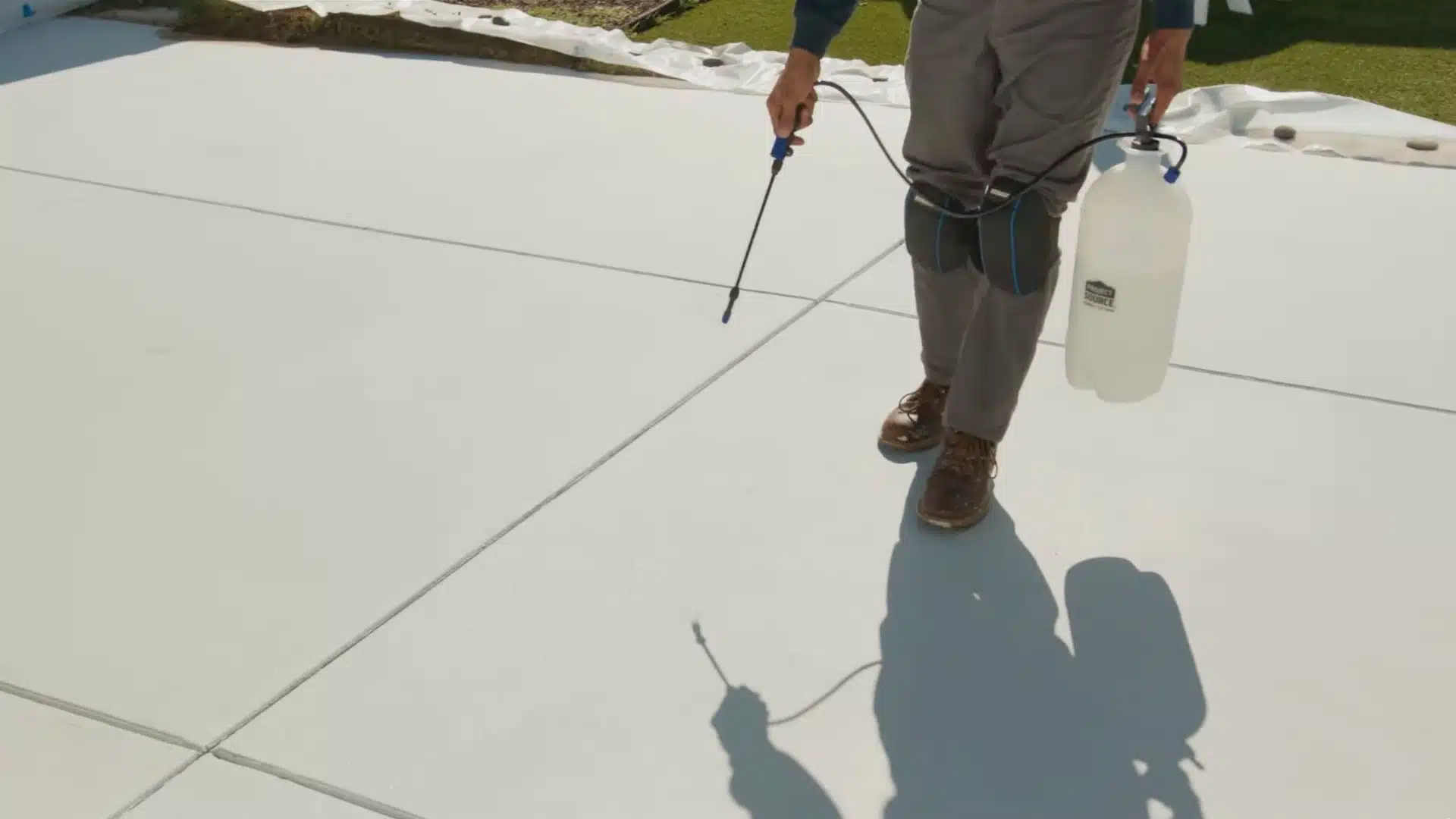 Concrete driveway being sealed with roller or sprayer for protection and durability