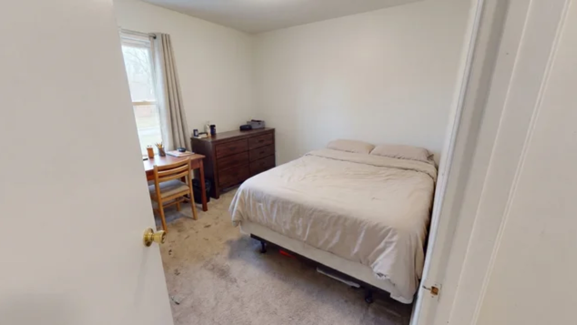 Queen-size bed with desk and dresser in a 10x12 foot bedroom with limited open floor space