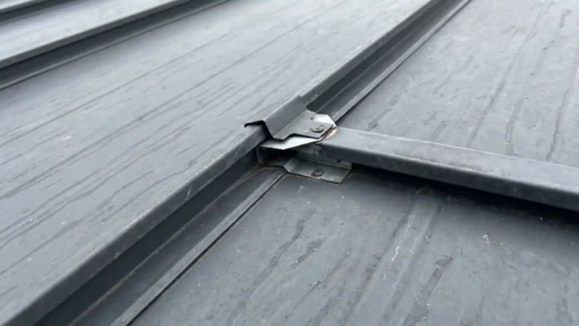 Close-up of a standing seam metal roof showing raised seam and concealed clip area