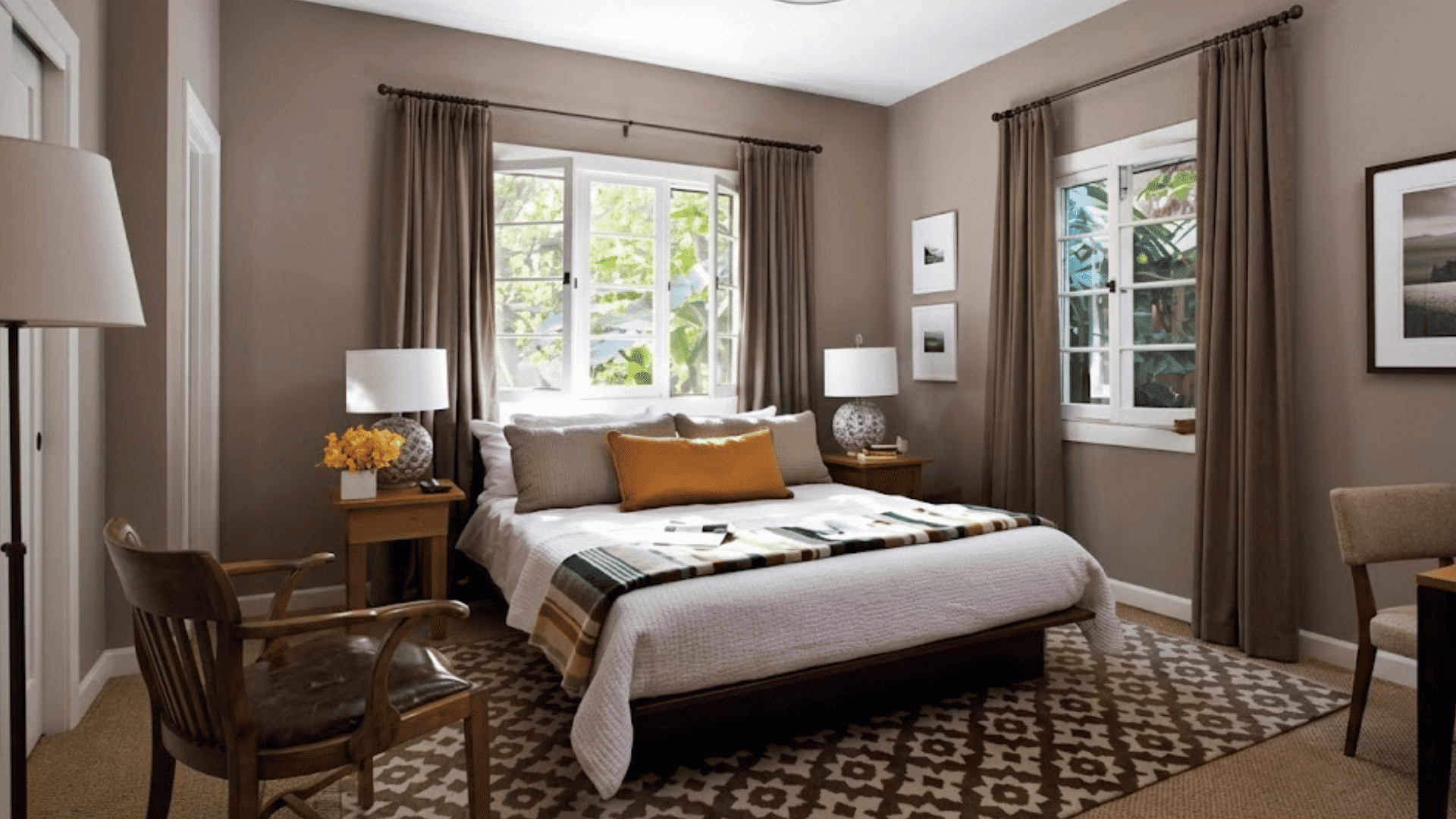 taupe monochromatic bedroom with layered neutral tones soft textiles wooden furniture and warm natural lighting