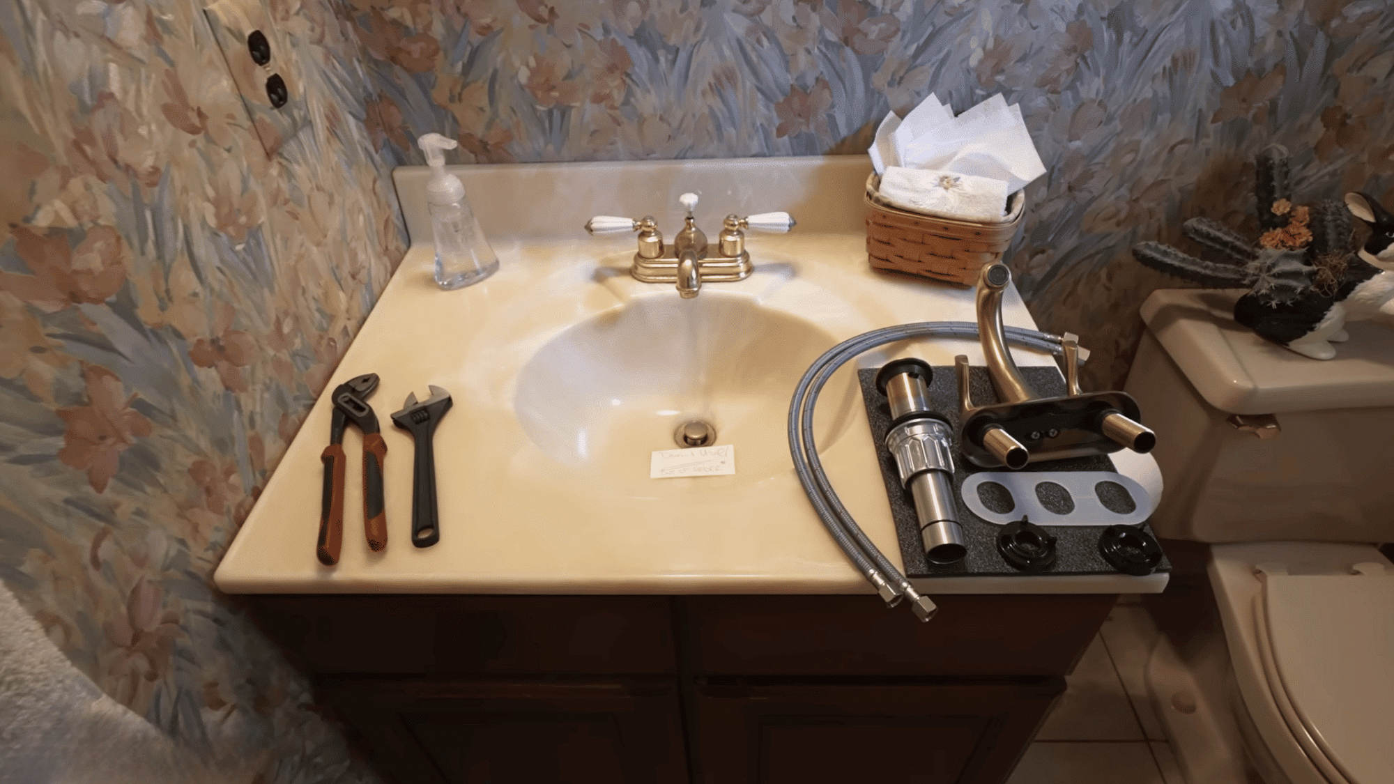tools and new bathroom faucet components organized on vanity before starting faucet replacement project