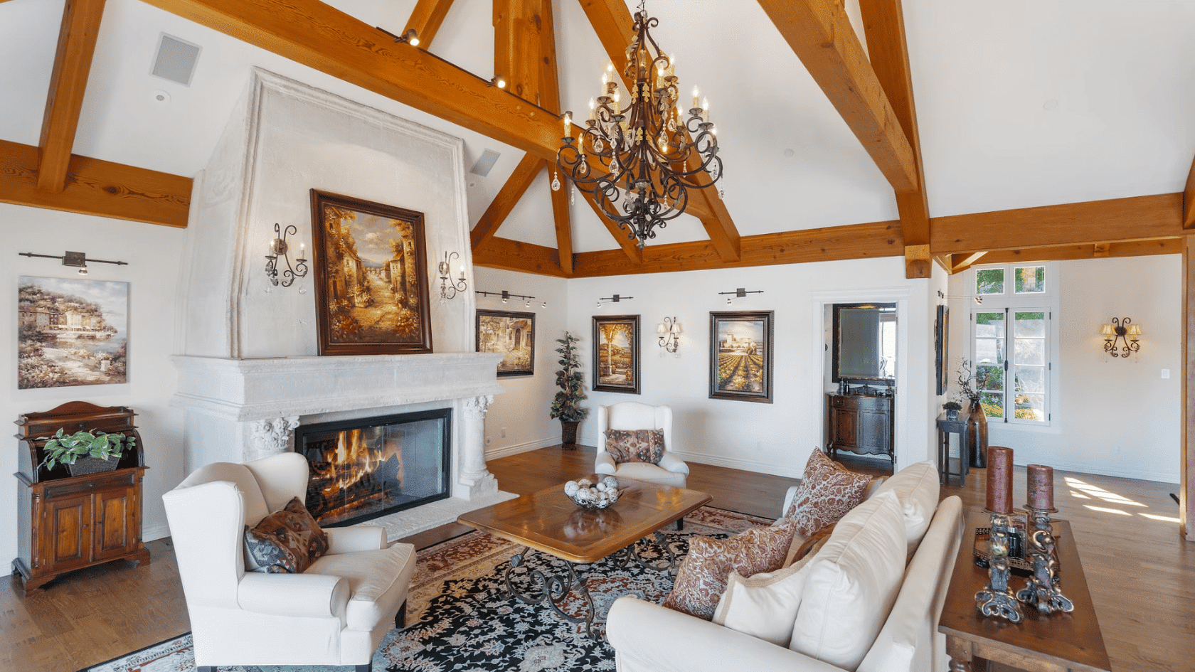 Traditional living room with exposed wood ceiling beams chandelier fireplace and classic furniture arrangement