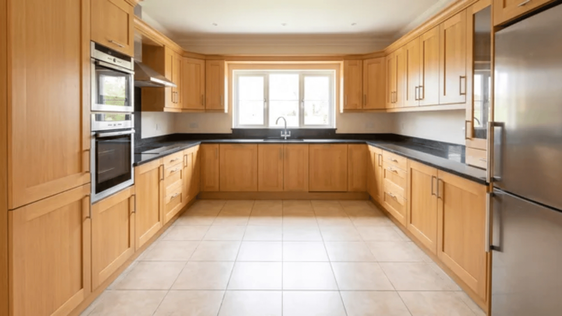 Kitchen with counters and cabinets arranged in a U shape along three walls with open center space
