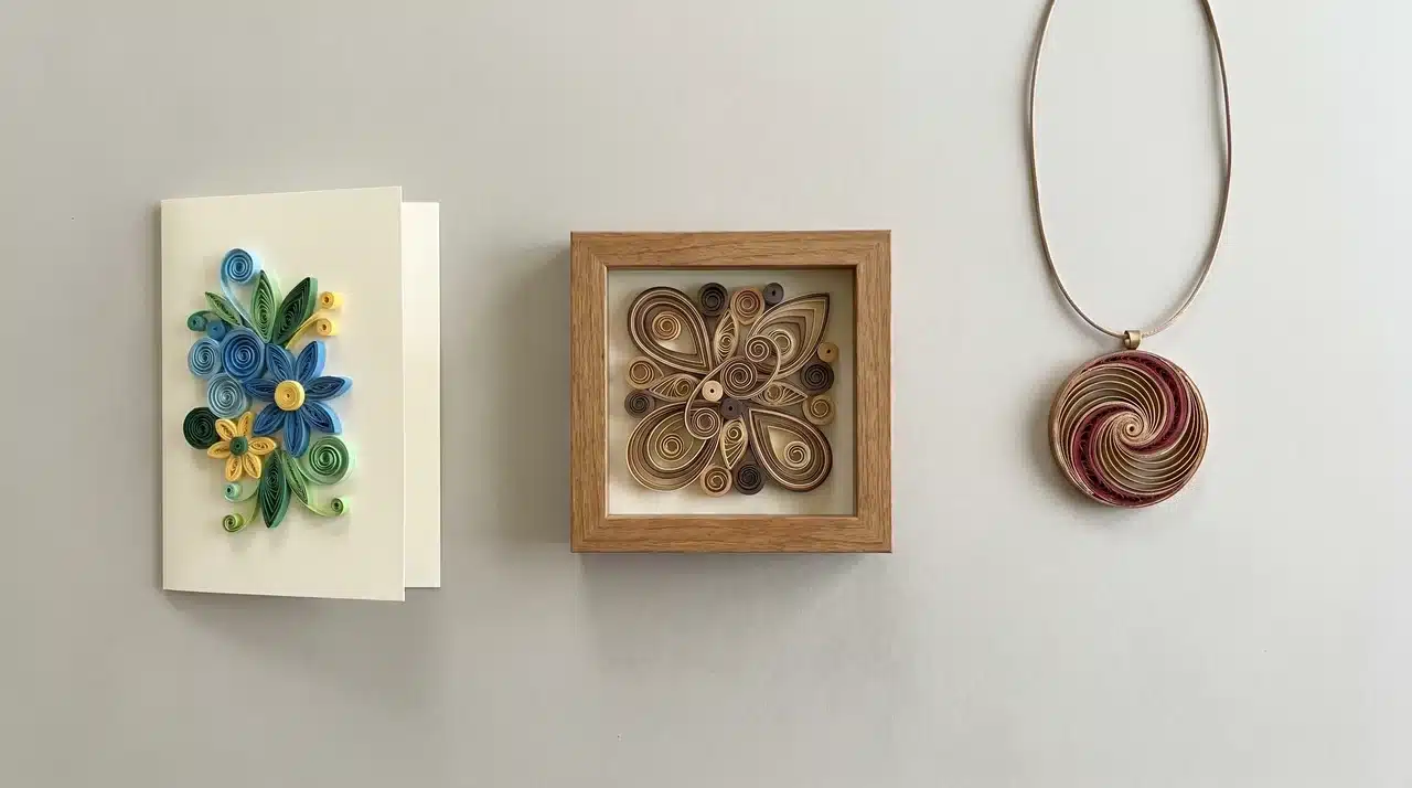 Quilled greeting card, small framed wall art, and paper quilling pendant arranged on a neutral surface