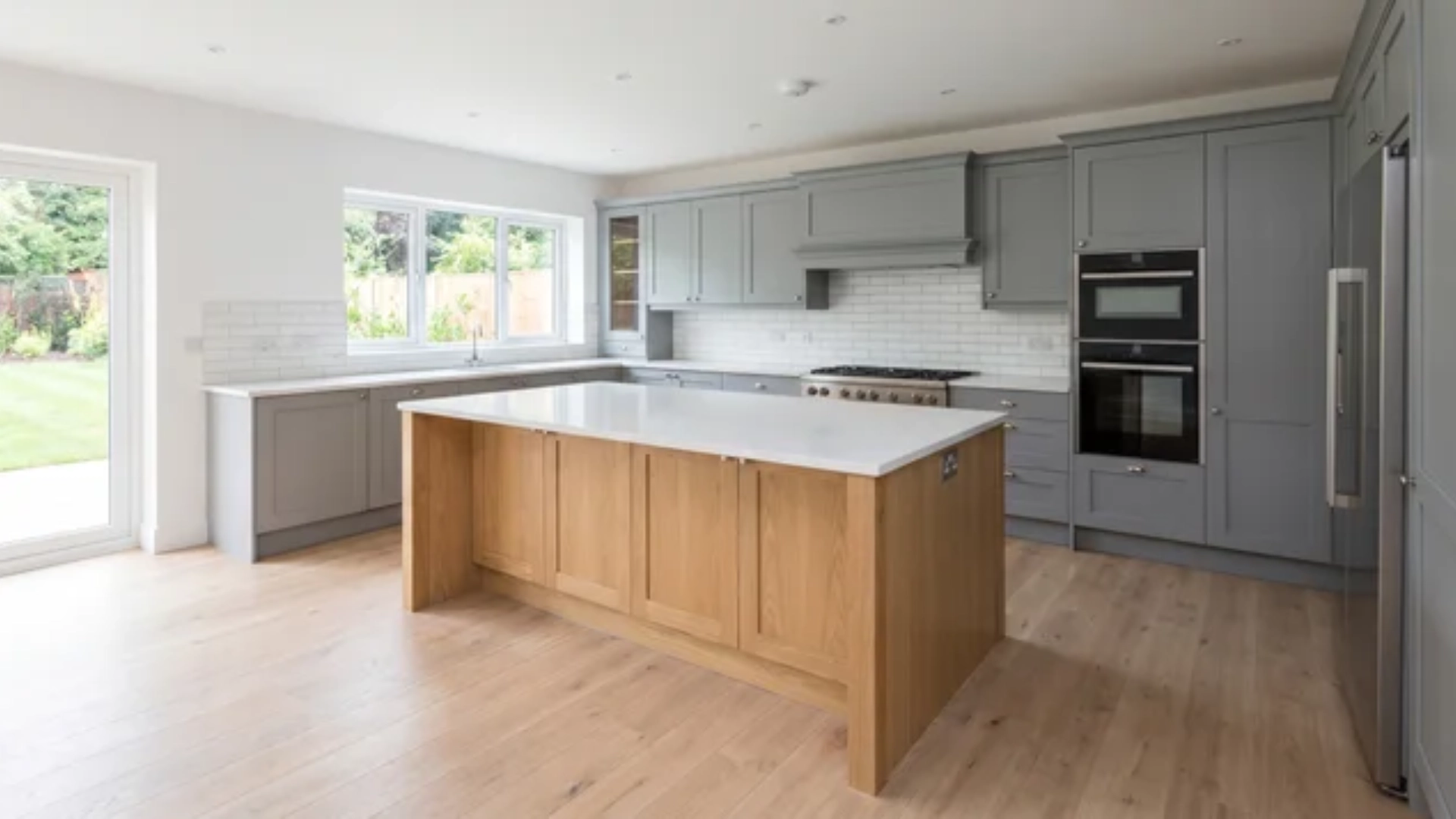 Kitchen interior with central island and surrounding cabinets showing clear walking space around island
