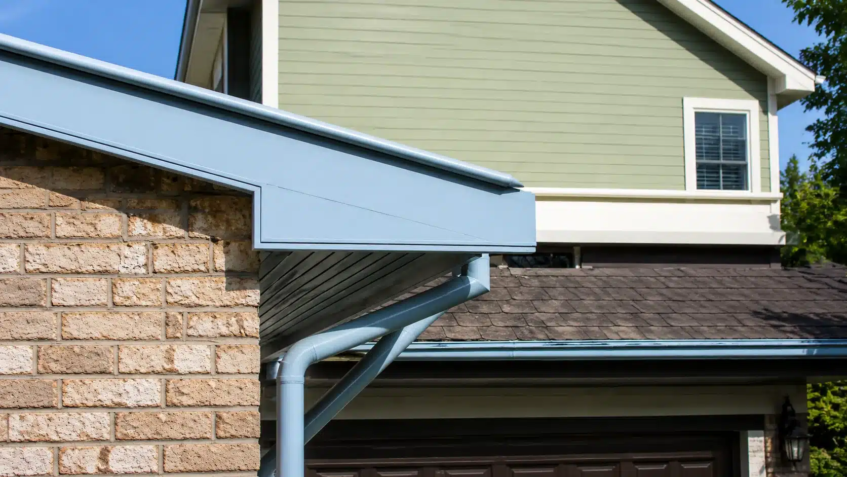 Light blue roof trim and gutter detail on a brick house exterior with siding and shingles.