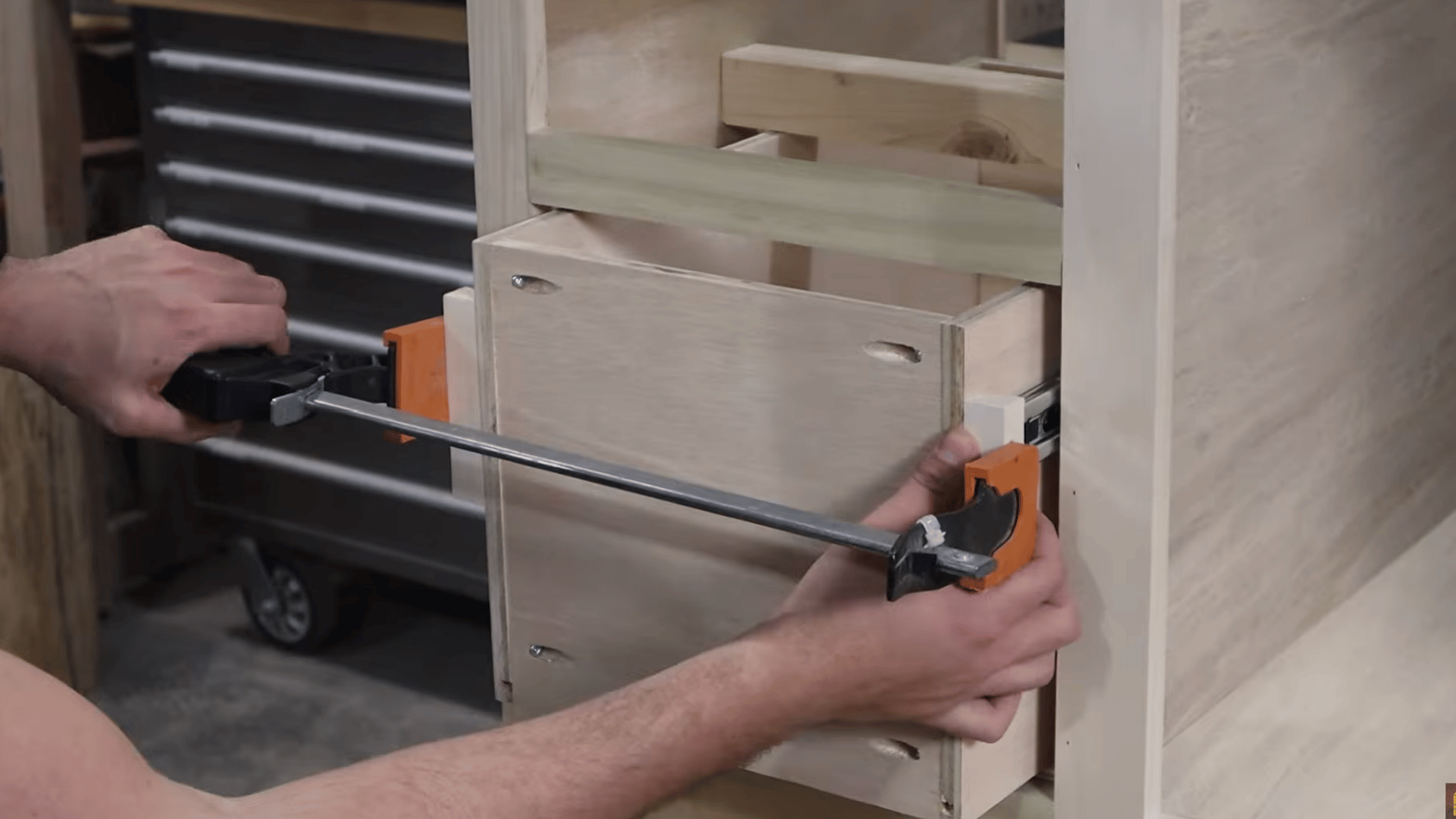 Installing drawer slides on wooden drawer boxes inside a custom-built vanity cabinet.