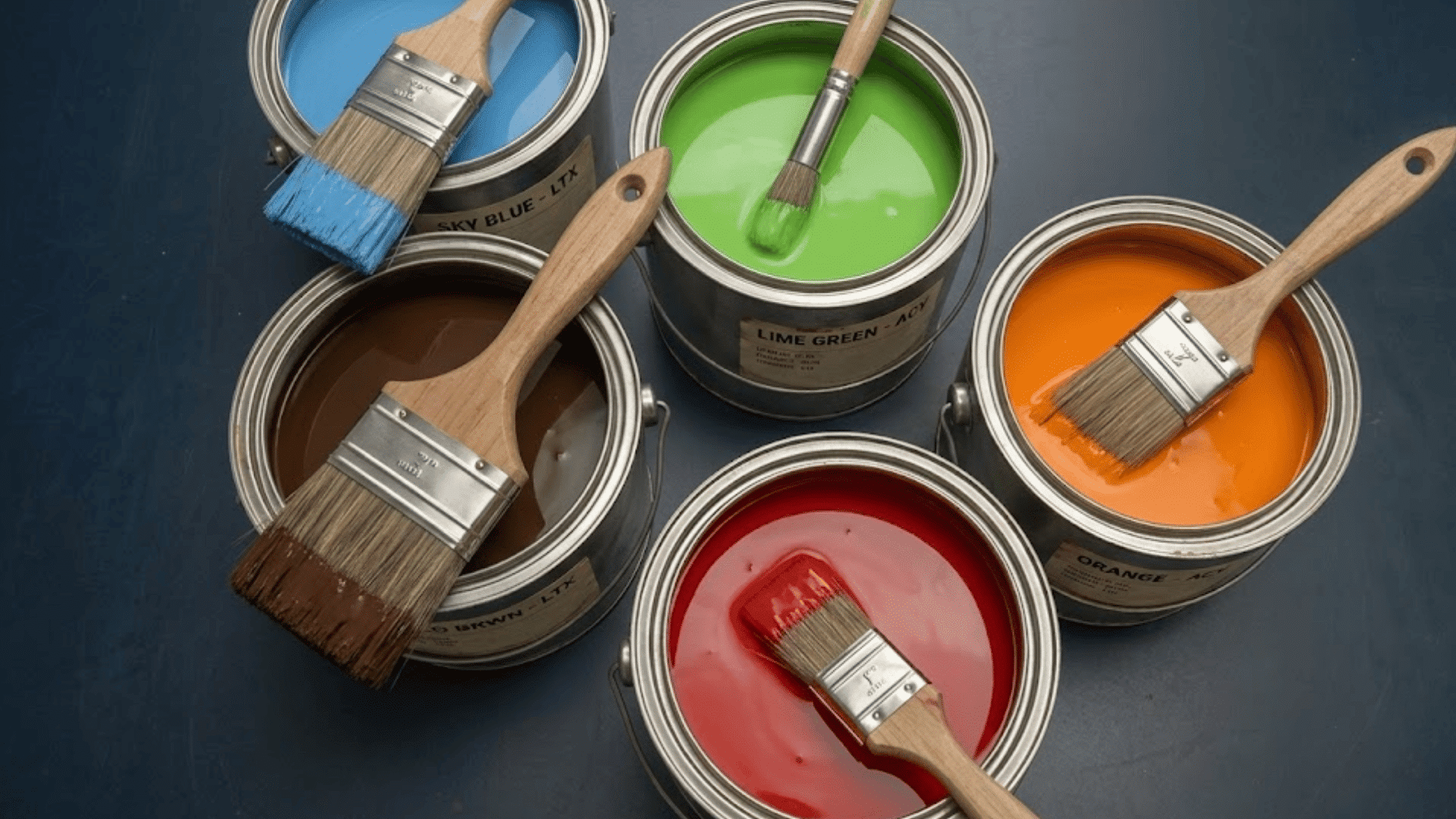 five open paint cans filled with blue green orange red and brown paint each holding a paintbrush ready for painting projects