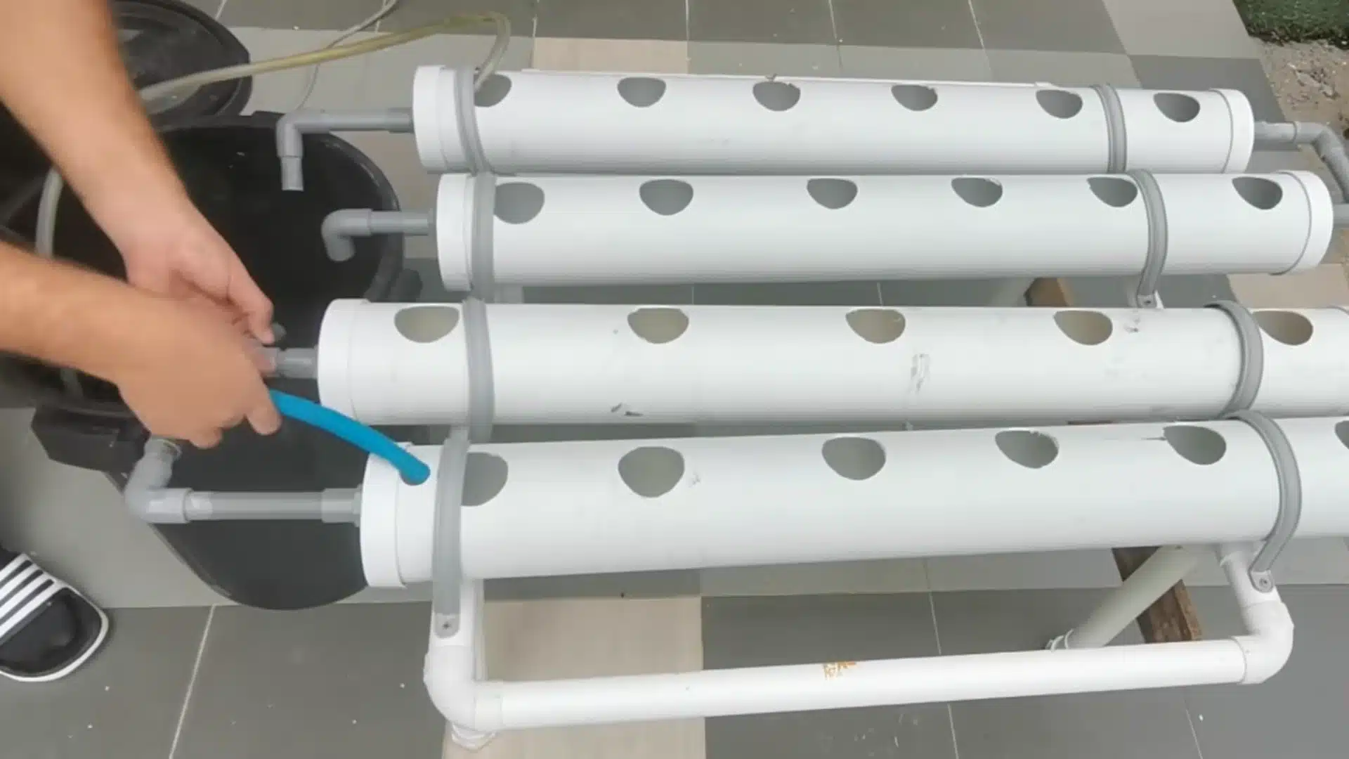 installing water hoses and connectors on pvc pipes for a diy hydroponic system water circulation setup