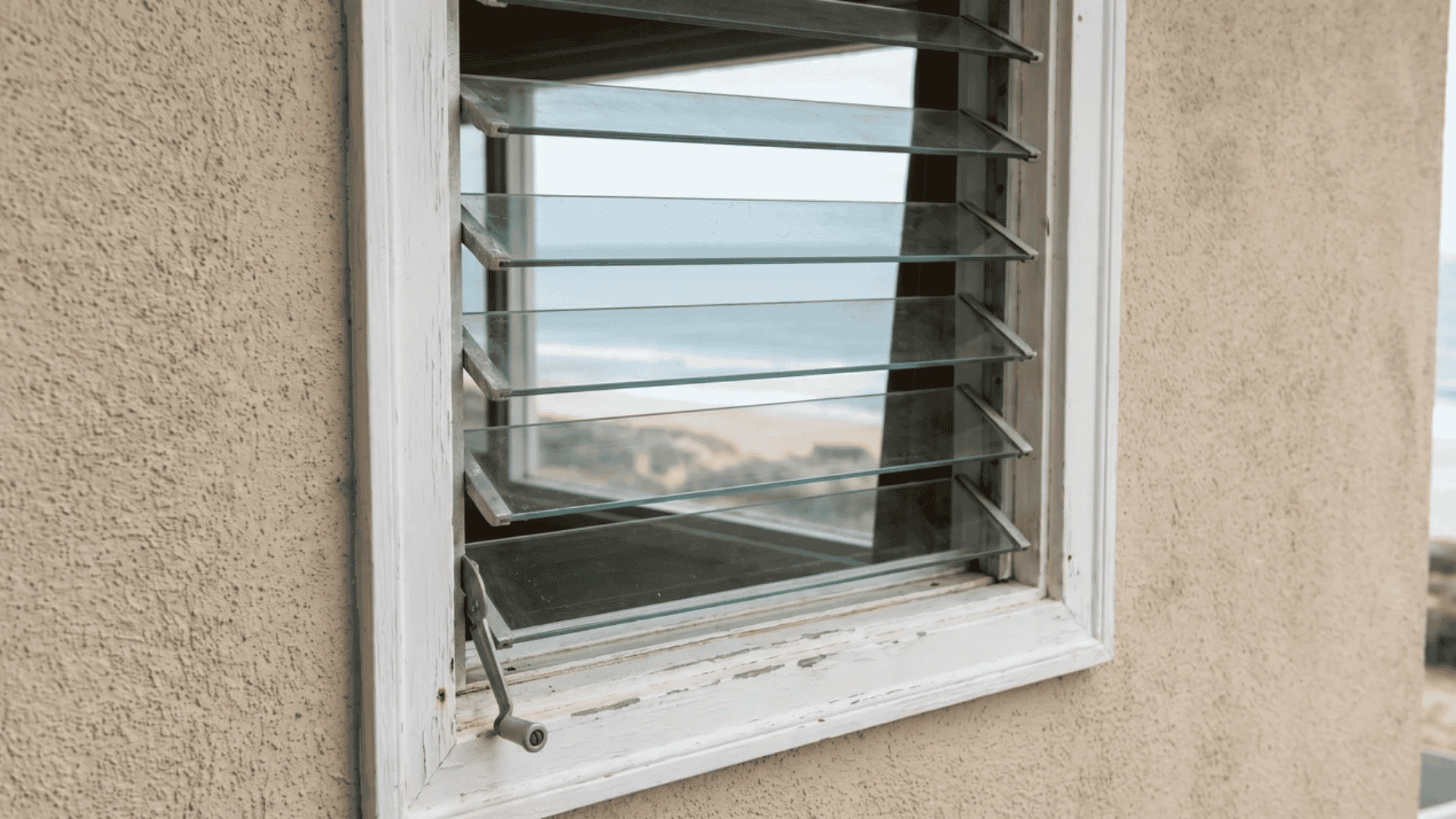 Louvered window with horizontal glass slats opened outward