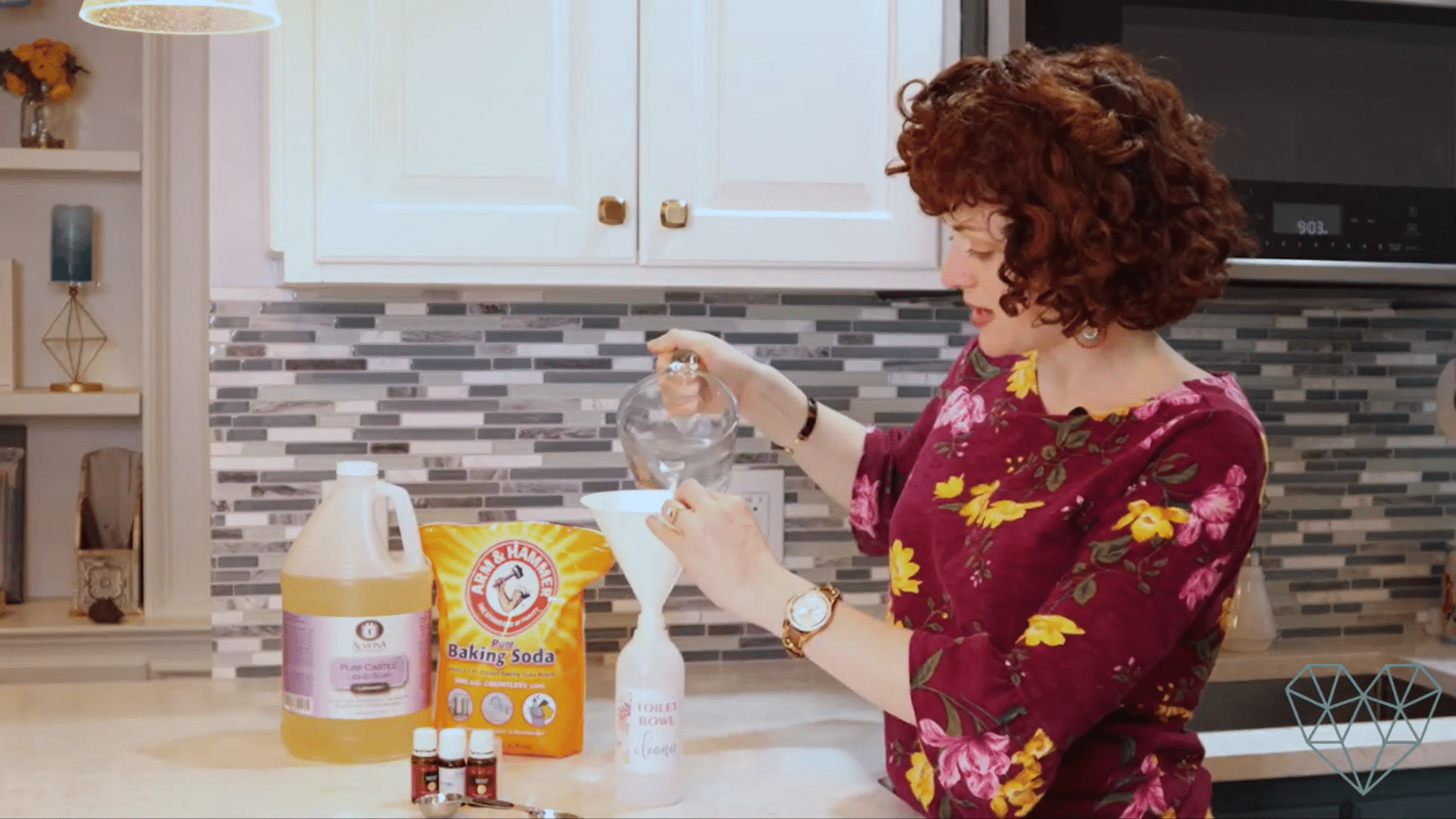 pouring water through a funnel into a reusable bottle to make diy toilet bowl cleaner with castile soap baking soda and essential oils on the counter
