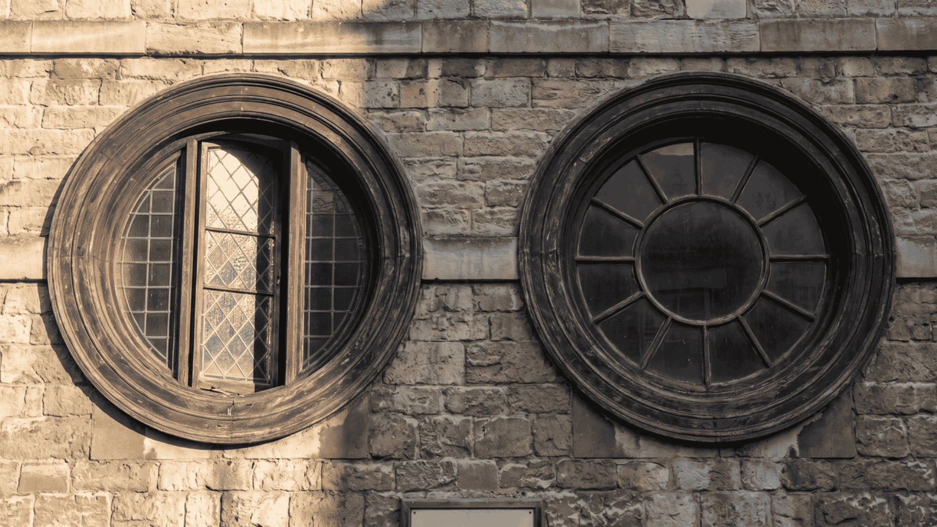 Round circular windows set into a stone building wall