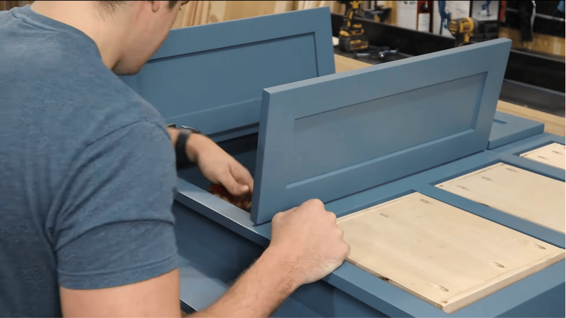 Applying finishing steps to vanity parts with sanding, priming, and painting before assembly.