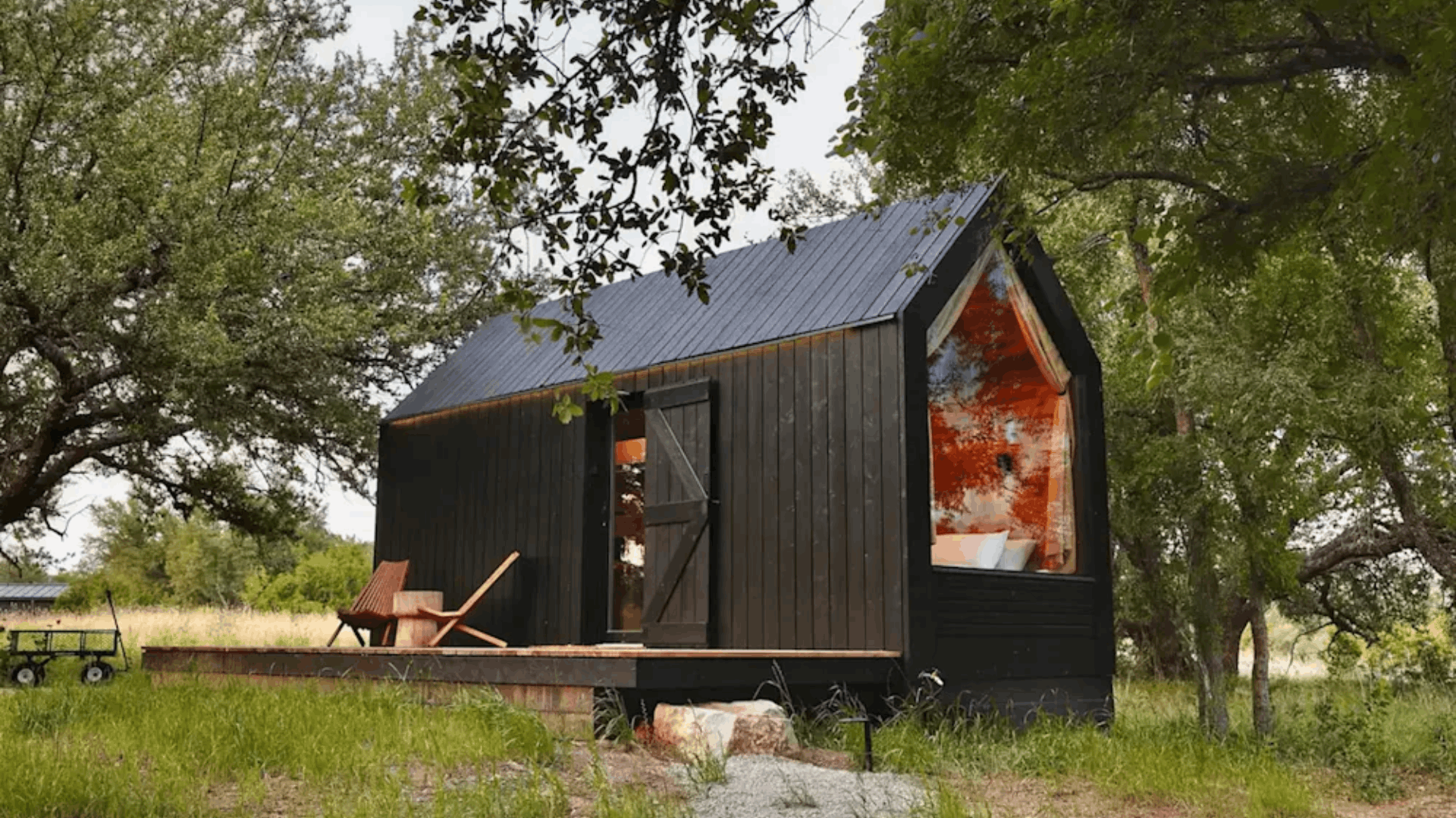 small wooden cabin surrounded by trees with simple roof design and budget friendly construction for year round living