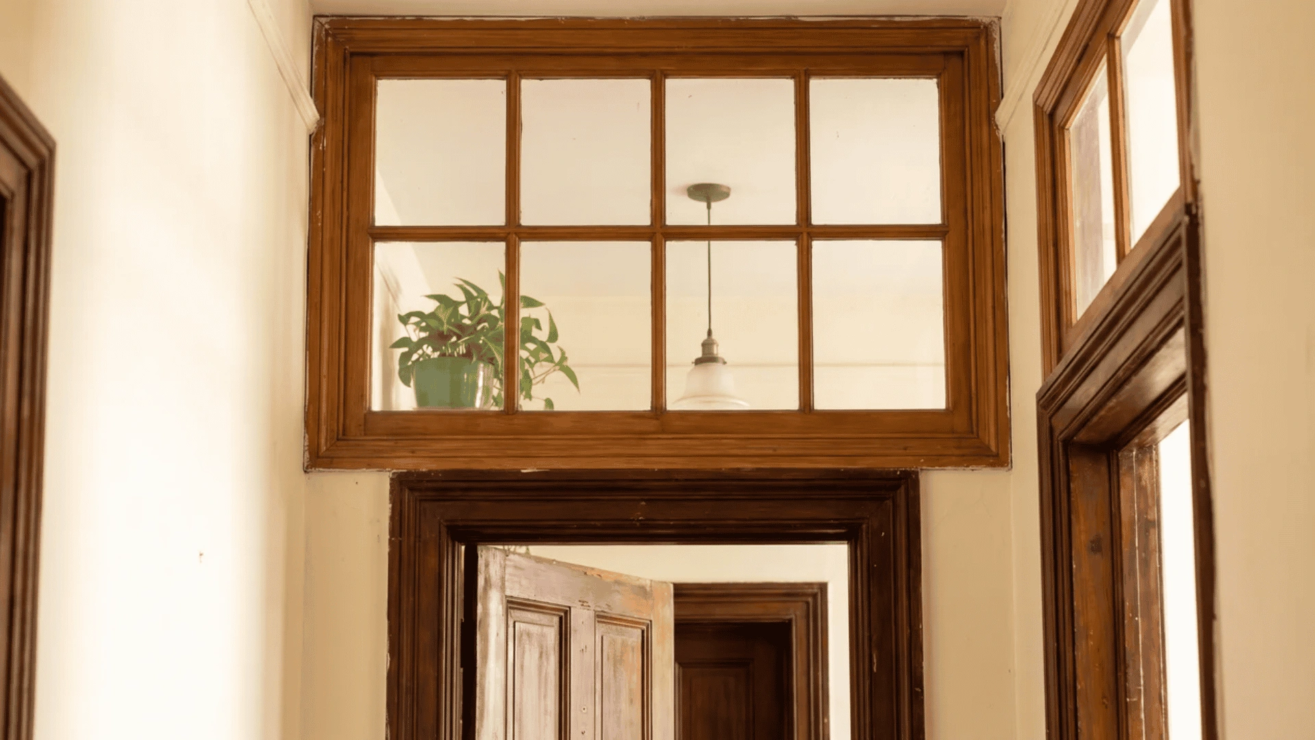 Wooden transom window above an interior doorway opening