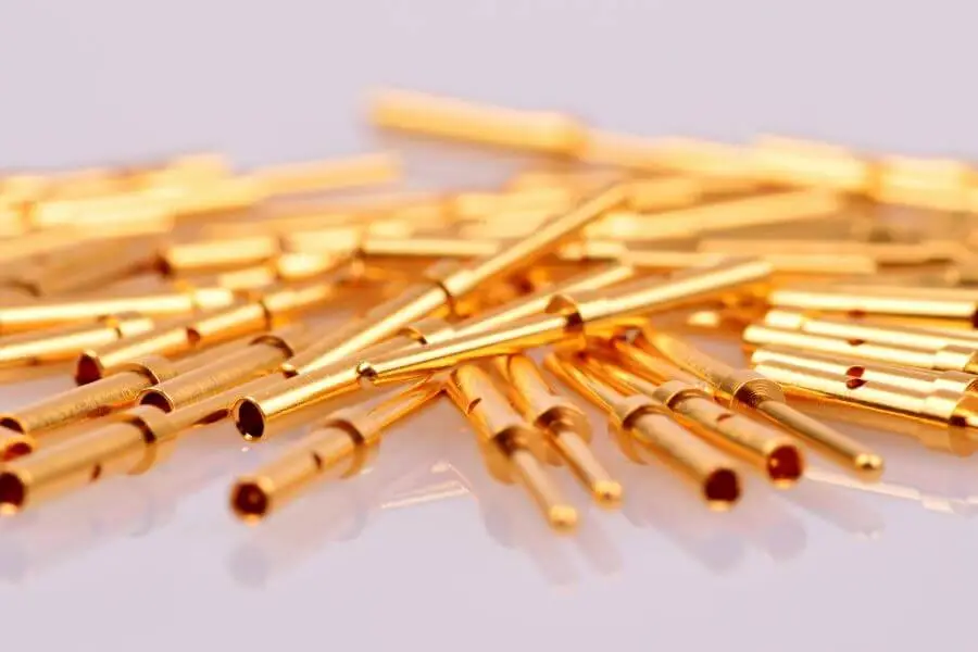 Types of Cable Lugs Explained: How to Choose the Right Connector Gold-plated electrical connectors scattered on reflective white surface