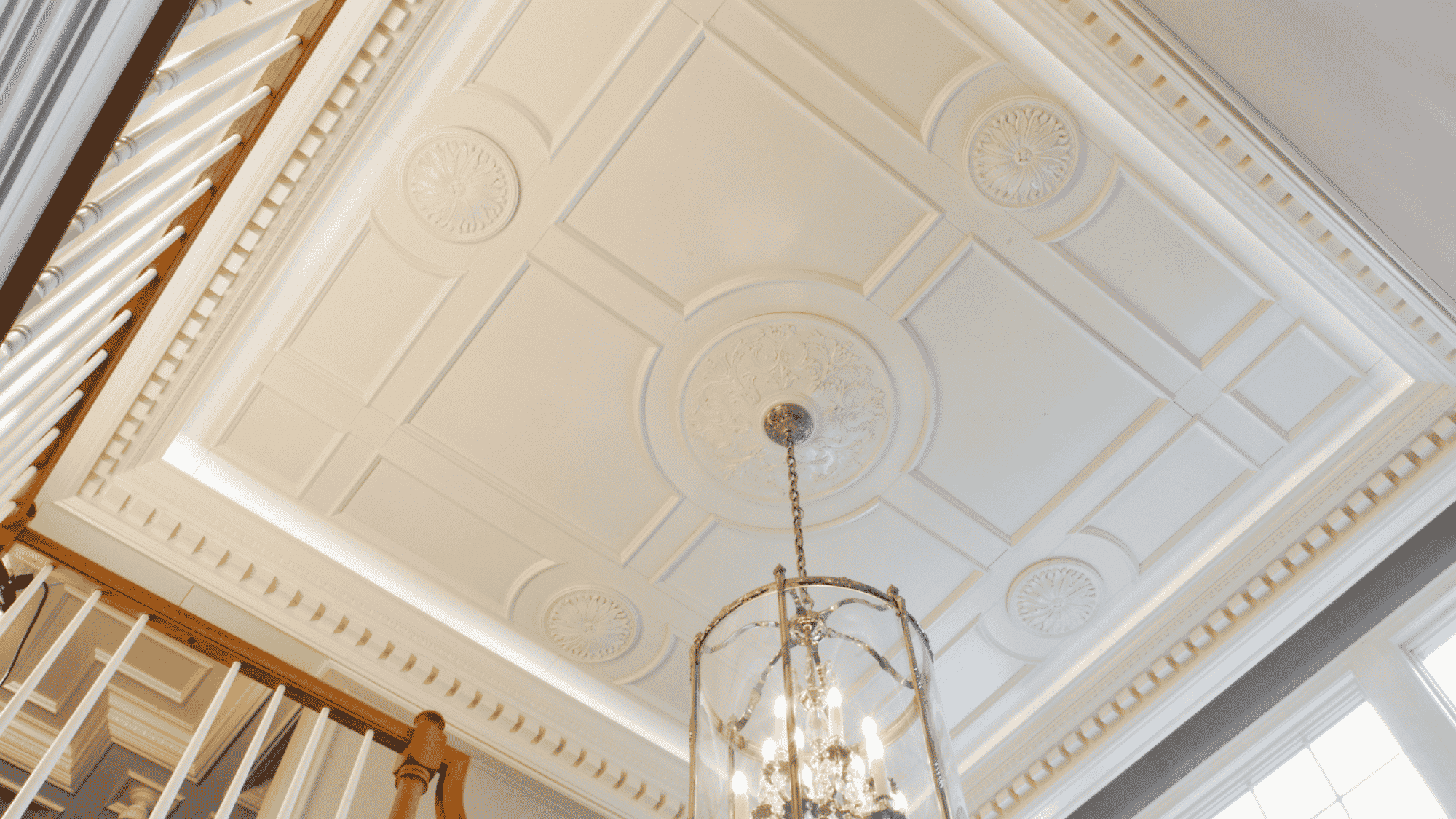white on white tray ceiling with elegant panel detailing and soft recessed lighting creating a bright timeless interior